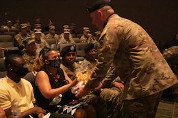 Soldier hands roses to family at ceremony