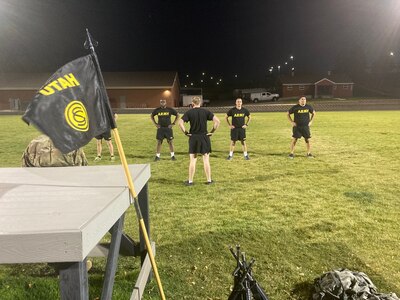 Five soldiers exercising on a field.