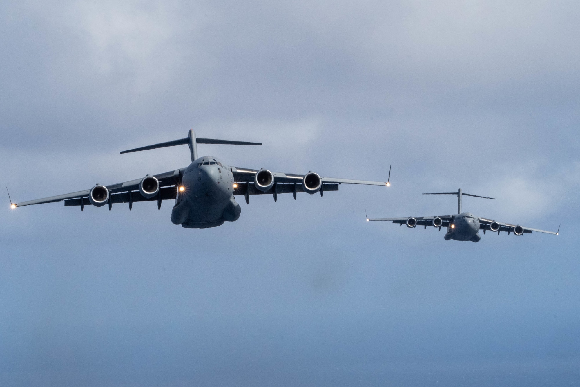 A U.S. Air Force C-17 Globemaster III flies alongside a Royal Australian Air Force C-17 in formation over the Pacific Ocean as part of Exercise Global Dexterity 2022 at Joint Base Pearl Harbor-Hickam, Hawaii, May 4, 2022. The RAAF squadron visited JBPHH to join both active duty and National Guard C-17s for training missions around the Hawaiian Islands to develop tactical airlift and airdrop capabilities. (U.S. Air Force photo by Airman 1st Class Makensie Cooper)