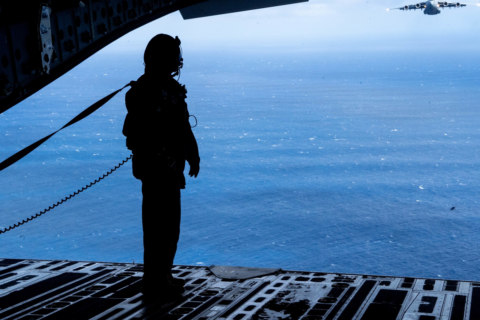 U.S. Air Force Senior Master Sgt. Kale Barney, 201st Air Mobility Operations Squadron loadmaster, stands at the end of the ramp of a C-17 Globemaster III watching a Royal Australian Air Force C-17 during Exercise Global Dexterity 2022 at Joint Base Pearl Harbor-Hickam, Hawaii, May 4, 2022. Exercise Global Dexterity 2022 is designed to help develop the bilateral tactical airlift and airdrop capabilities of the U.S. Air Force and the Royal Australian Air Force. (U.S. Air Force photo by Airman 1st Class Makensie Cooper)