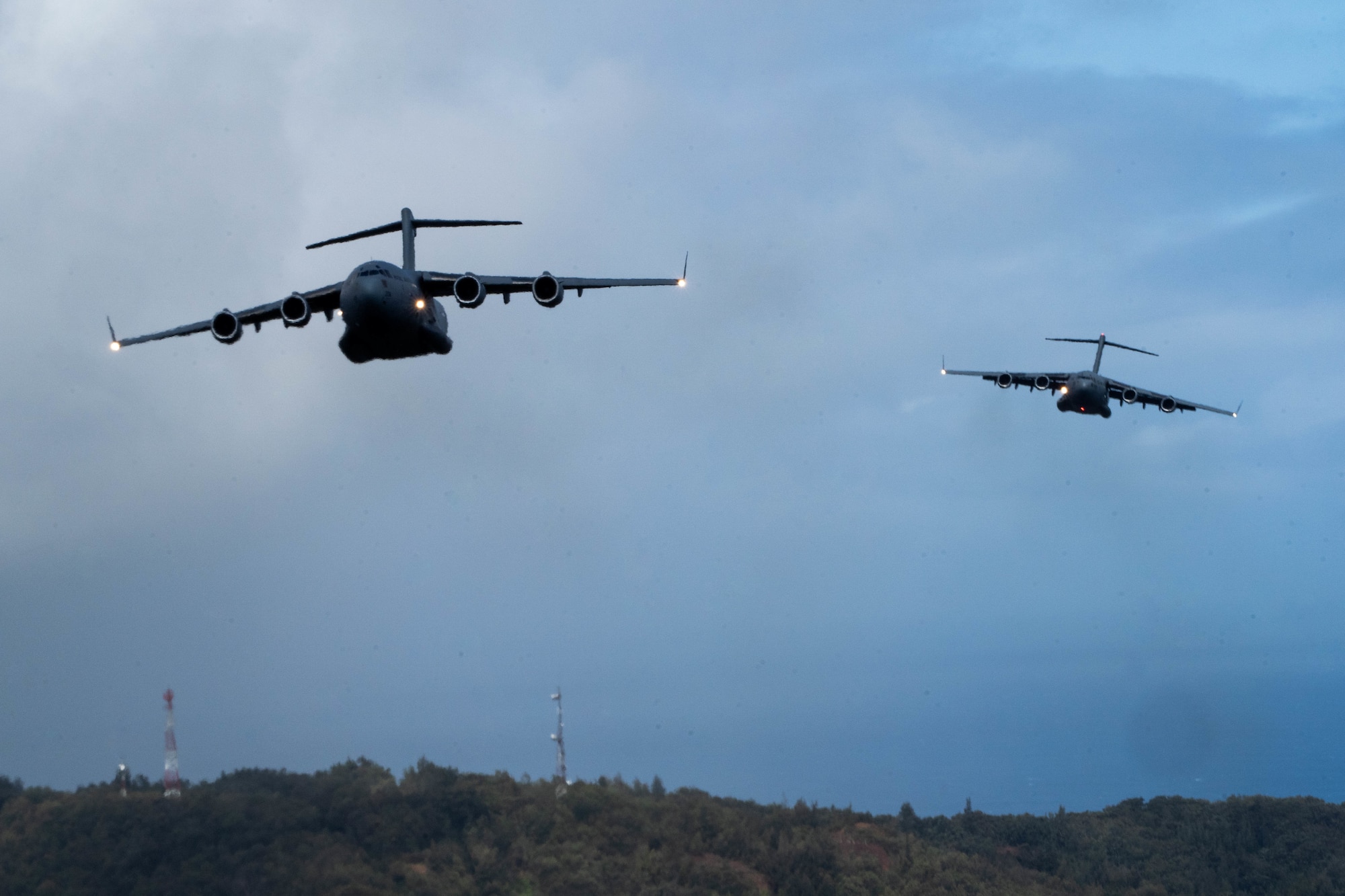 A Royal Australian Air Force C-17 Globemaster III flies in formation with a U.S. C-17 during an aerial maneuver training mission around the Hawaiian islands as part of Exercise Global Dexterity 2022 at Joint Base Pearl Harbor-Hickam, Hawaii, May 4, 2022. The RAAF and USAF conducted joint flying missions alongside each other and swapped aircrew members to better learn of each others’ procedures and techniques. (U.S. Air Force photo by Airman 1st Class Makensie Cooper)