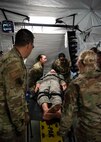 Military medical personnel attend to a training mannequin during a medical simulation during the Expeditionary Medical Support System training at Joint Base Andrews, Md., May 5, 2022.