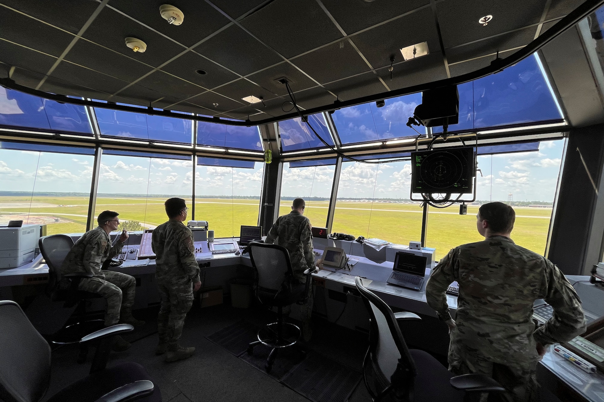 A photo of airmen standing at the top of the control tower.