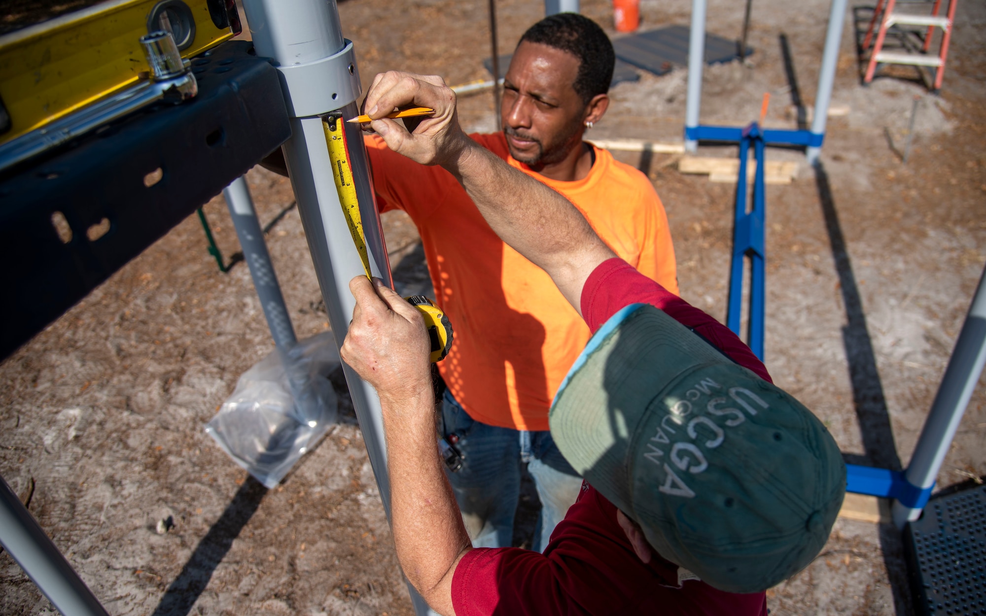 Contractors take measurements while building an all-inclusive park at MacDill Air Force Base, Florida, March 9, 2022. The playground was built specifically to meet the needs of the Exceptional Family Member Program and the Americans with Disabilities Act to ensure children of all ages and abilities have a safe area to play outdoors. (U.S. Air Force photo by Airman 1st Class Lauren Cobin)