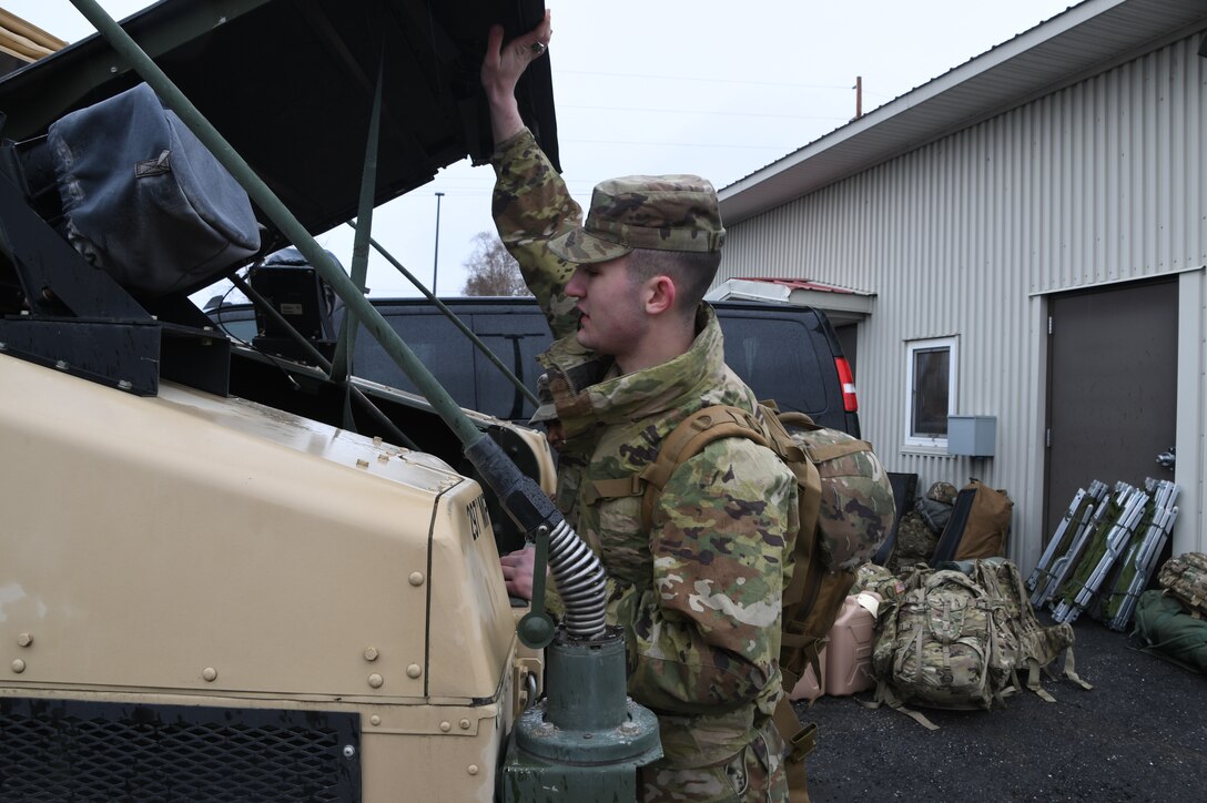 Alaska Army National Guard Soldier, Pfc. Harlan Hartman of the 297th Military Police Company ensures gear and necessary equipment are loaded into a National Guard Humvee at the Fairbanks National Guard Armory in preparation to travel to Manley Hot Springs, Alaska, May 12, 2022, to support flood recovery operations. The Guardsmen will assist with cleanup and flood recovery efforts at the request of the State of Alaska Emergency Operations Center. (Alaska National Guard photo by Senior Master Sgt. Julie Avey)