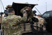 Alaska Army National Guard Soldiers Pfc. Harlan Hartman of 297th Military Police Company and Spc. Kyle Johnson of the 297th Regional Support Group load gear, water, equipment, and fuel in preparation to travel to Manley Hot Springs, Alaska, May 12, 2022, to support flood recovery operations. The Guardsmen will carry enough food and water to sustain themselves while they assist with cleanup and flood recovery efforts. (Alaska National Guard photo by Senior Master Sgt. Julie Avey)