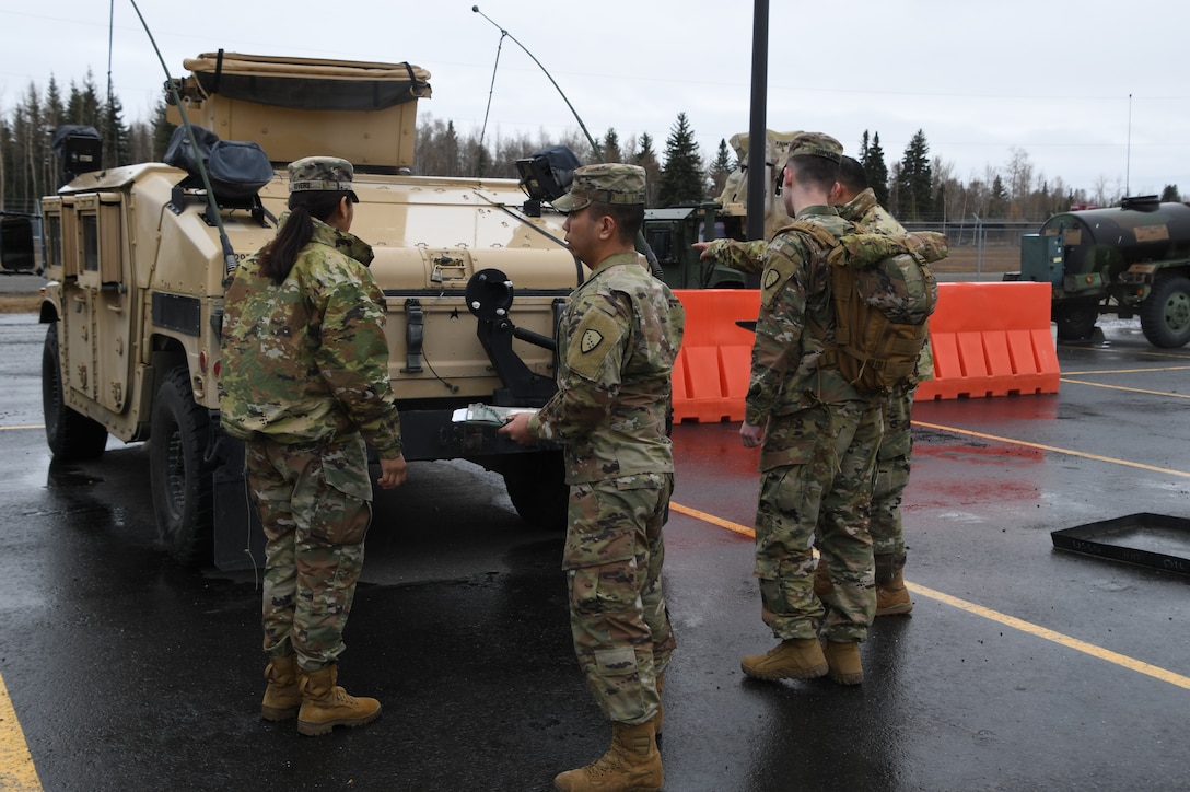 Pvt. Frederica Rivers of the 207th Engineer Company, Spc. Steven Romero and Pfc. Harlan Hartman of the 297th Military Police Company, and Spc. Kyle Johnson of the 297th Regional Support Group inspect vehicles and load necessary equipment in preparation to travel to Manley Hot Springs, Alaska, May 12, 2022, to support flood recovery operations. The Guardsmen will assist with cleanup and flood recovery efforts at the request of the State of Alaska Emergency Operations Center. (Alaska National Guard photo by Senior Master Sgt. Julie Avey)