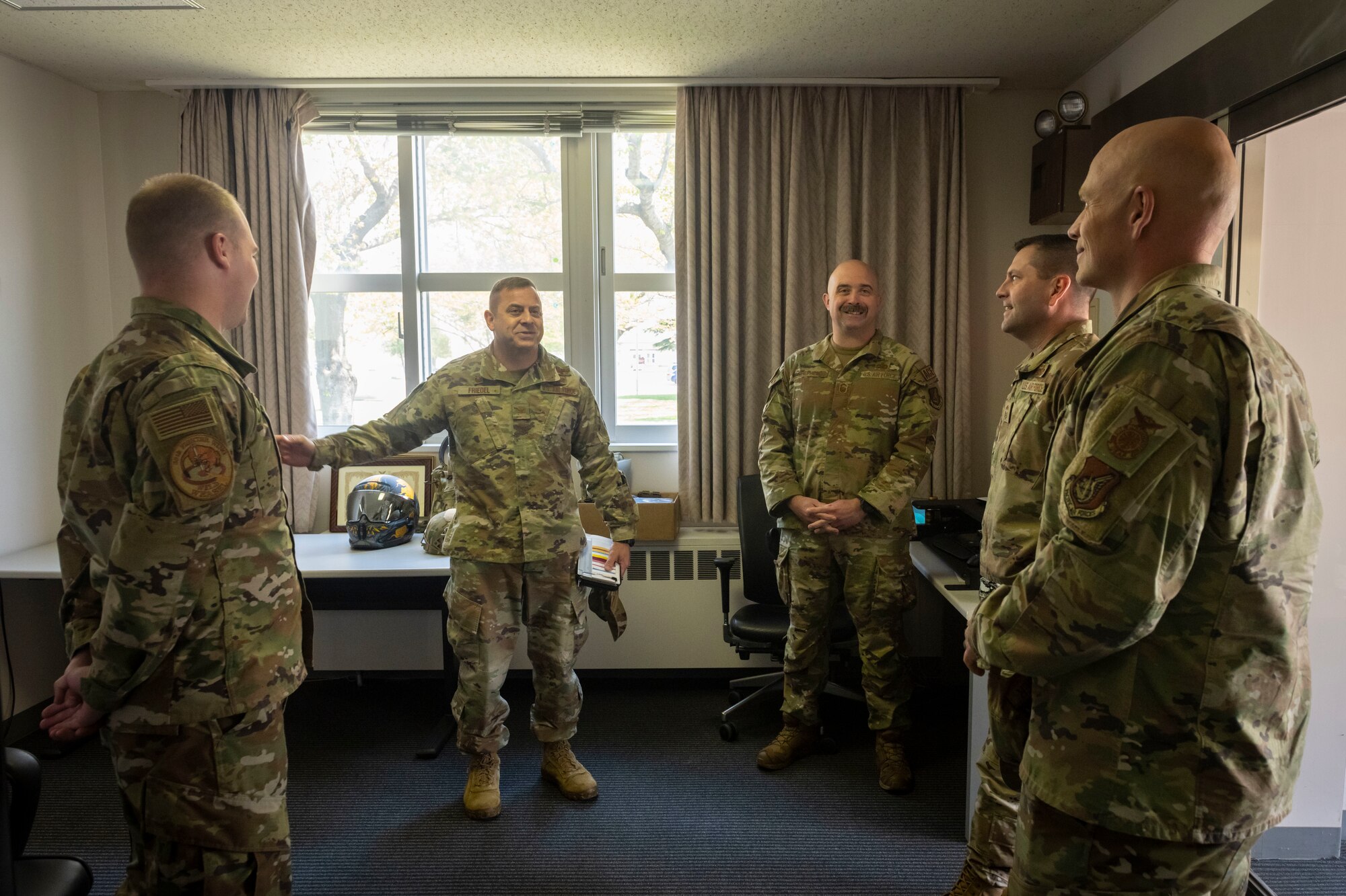 Military members in uniform talk to each other