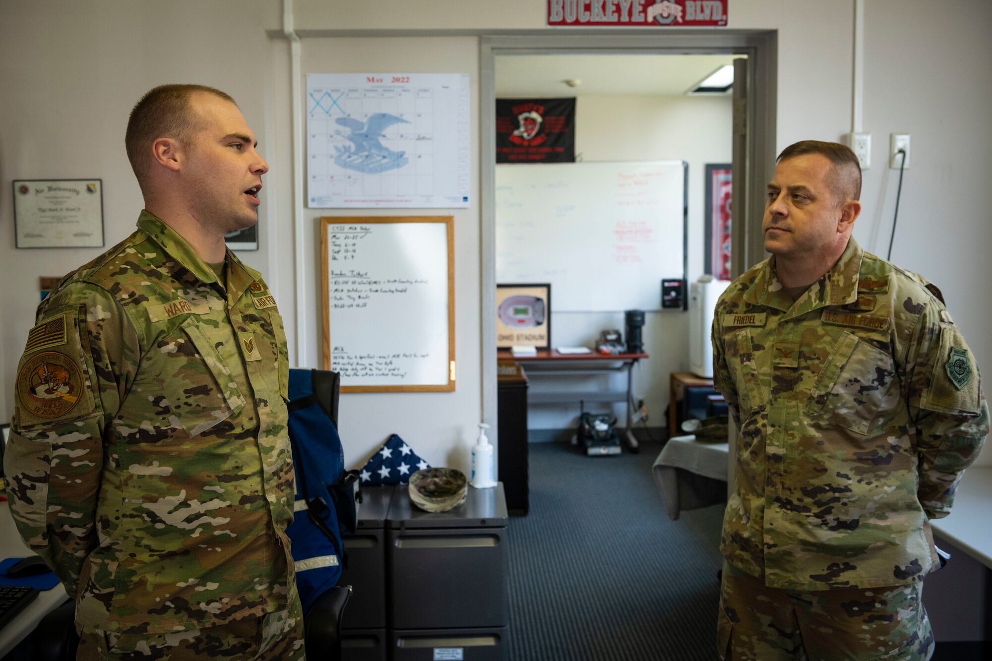 Military members in uniform talk to each other