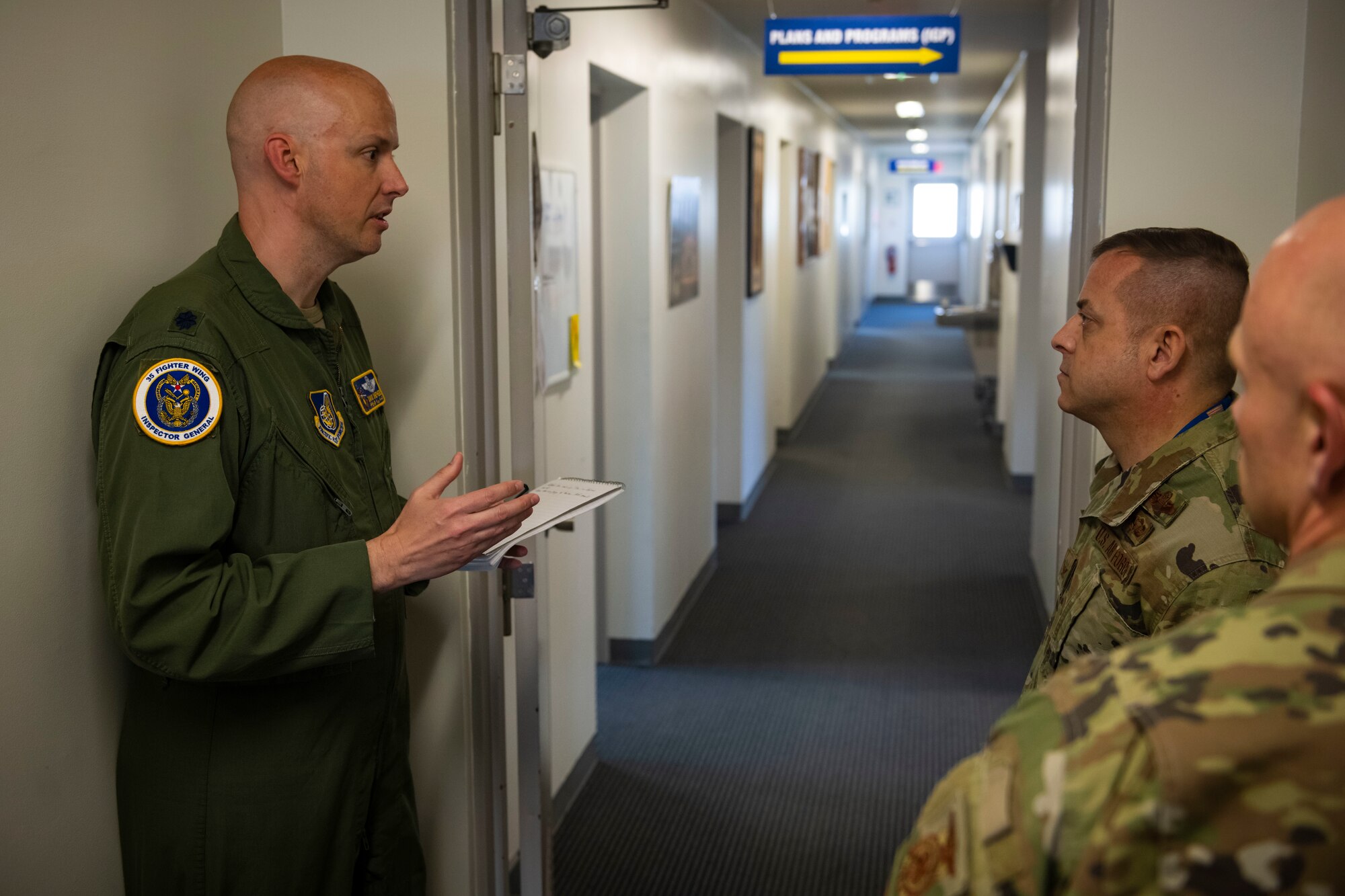 Military members in uniform talk to each other