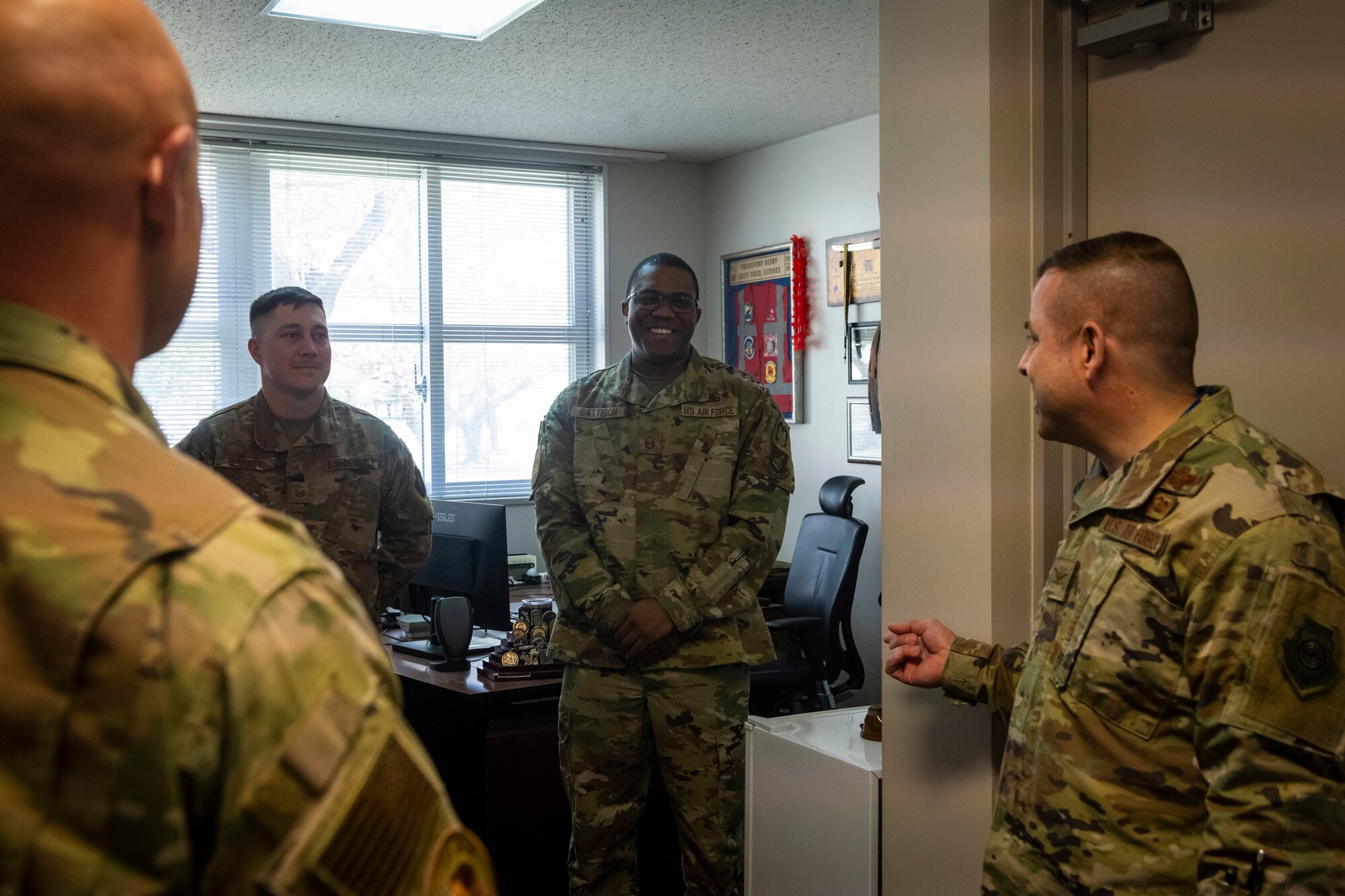 Military members in uniform talk to each other