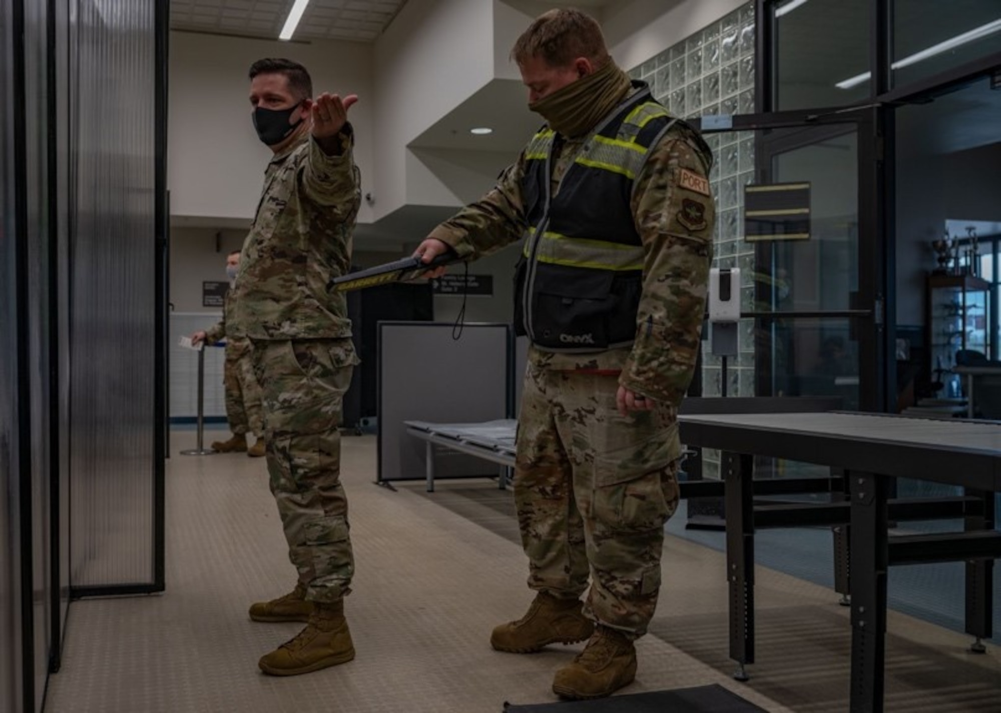 62nd Aerial Port Squadron Airmen simulate security magnetometer procedures during Patriot Express training at Joint Base Lewis-McChord, Washington, May 4, 2022. The PE mission is a commercial charter mission supporting official-duty travelers and their families to overseas locations, operating out of the McChord Passenger Terminal for the first time. (U.S. Air Force photo by Airman 1st Class Charles Casner)