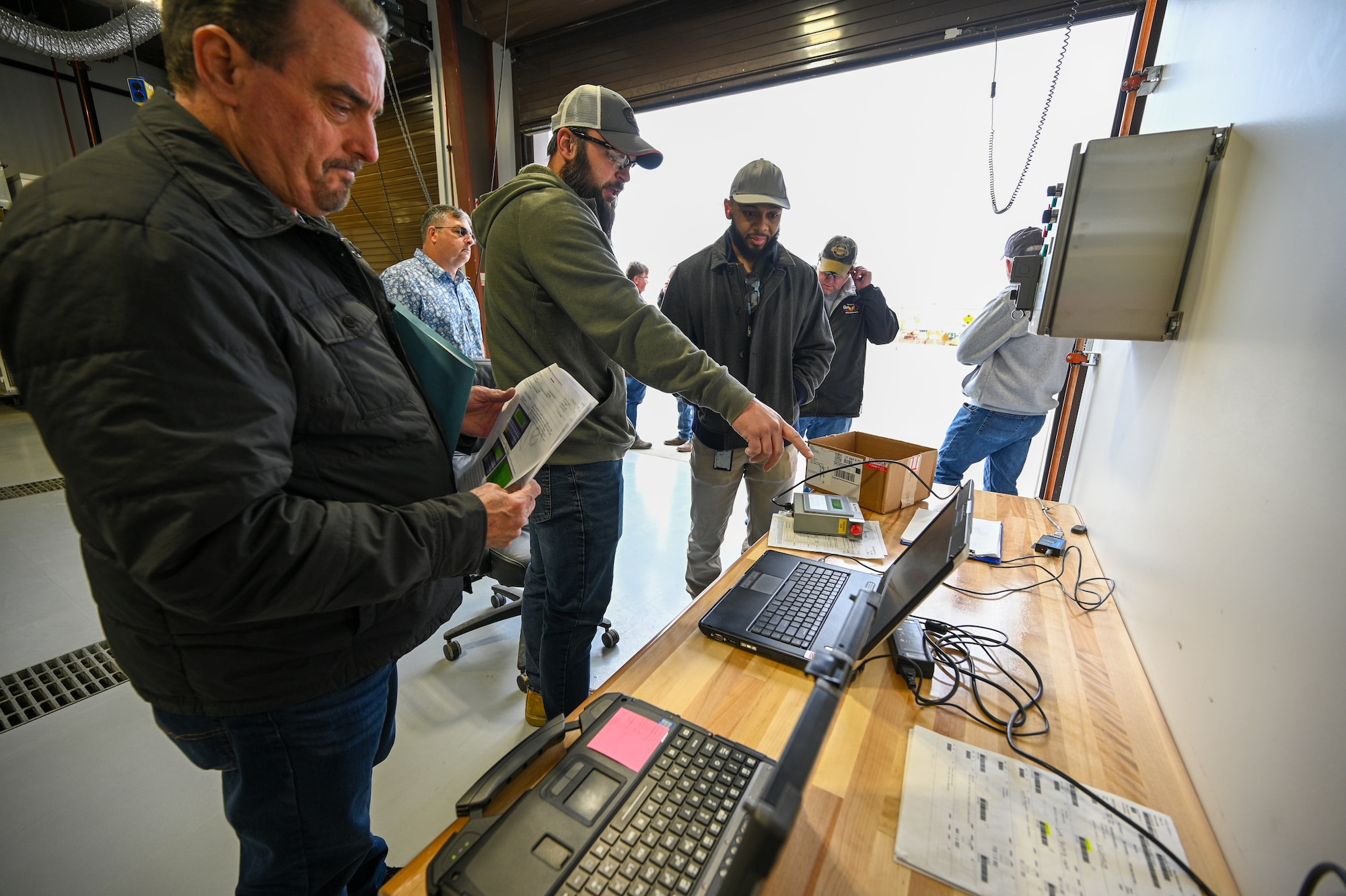 Center, Abe Erwin, 526th Electronics Maintenance Squadron, and Wilbert Hawthorne, BEAR Program Office, monitor validation and verification testing of a Base Expeditionary Airfield Resources (BEAR) power unit at Hill Air Force Base, Utah, April 26, 2022. The 526th EMXS activated a new maintenance workload on BEAR units after successfully testing the unit's first repaired asset. BEAR power units are used to power U.S. Air Force forward operating bases. (U.S. Air Force photo by R. Nial Bradshaw)