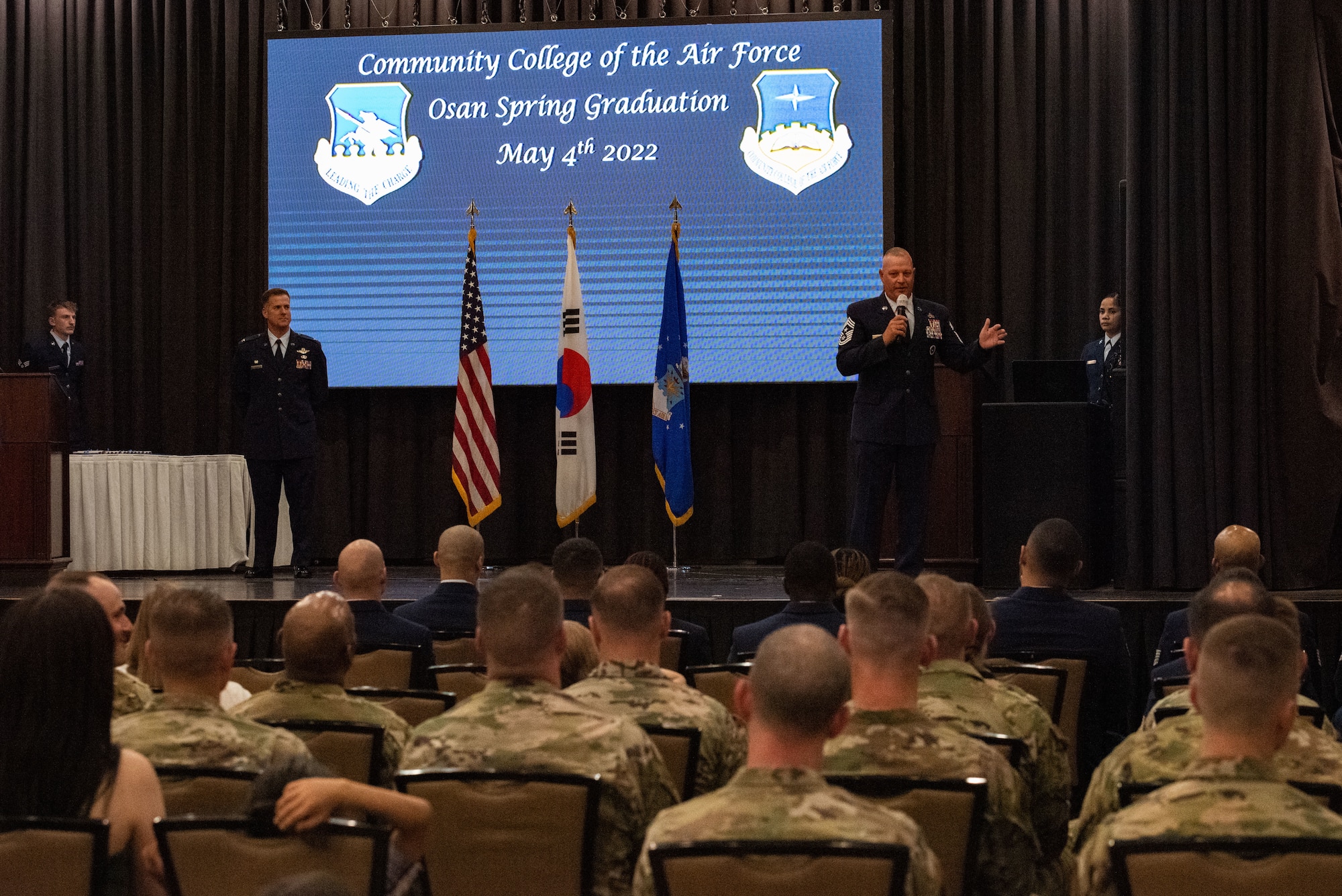 Chief Master Sgt. Justin Apticar delivers a congratulatory speech to the most recent CCAF graduates