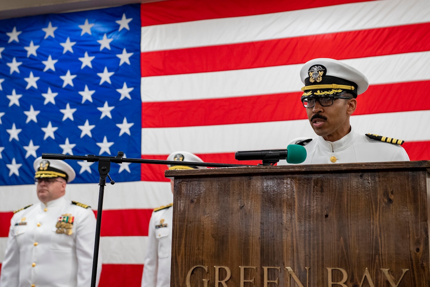 Capt. Severn B. Stevens, the new commanding officer of the forward-deployed amphibious transport dock ship USS Green Bay (LPD 20), gives remarks during his change-of-command ceremony in the ship’s vehicle stowage area. Green Bay, part of Amphibious Squadron 11, is operating in the U.S. 7th Fleet area of responsibility to enhance interoperability with allies and partners, and serve as a ready response force to defend peace and stability in the Indo-Pacific region. (U.S. Navy photo by Mass Communication Specialist Seaman Matthew Bakerian)