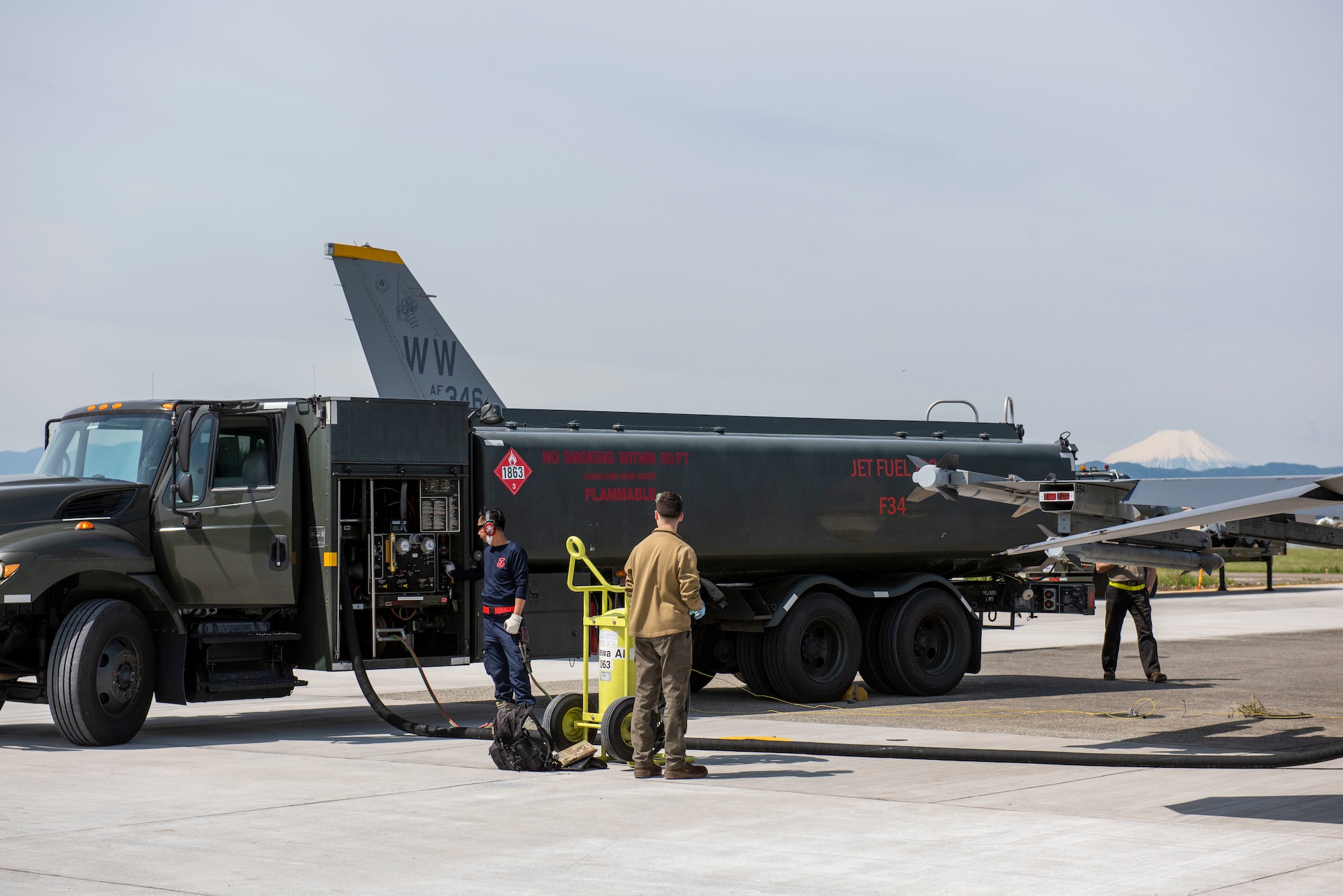 An operator distributes fuel to an F-16 Fighting Falcon jet