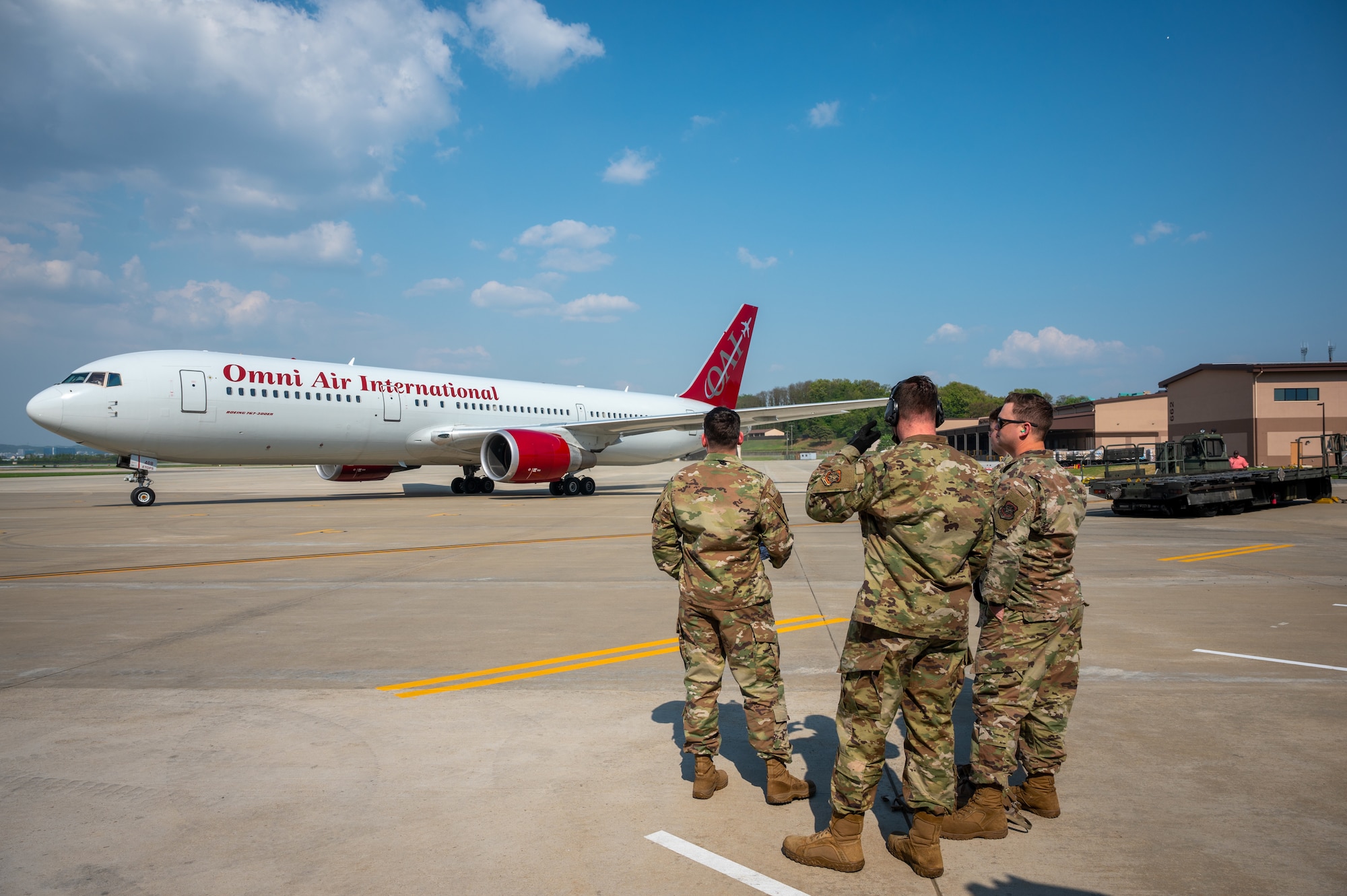 Members of the 731st Air Mobility Squadron wait to off load a rotator flight that has landed