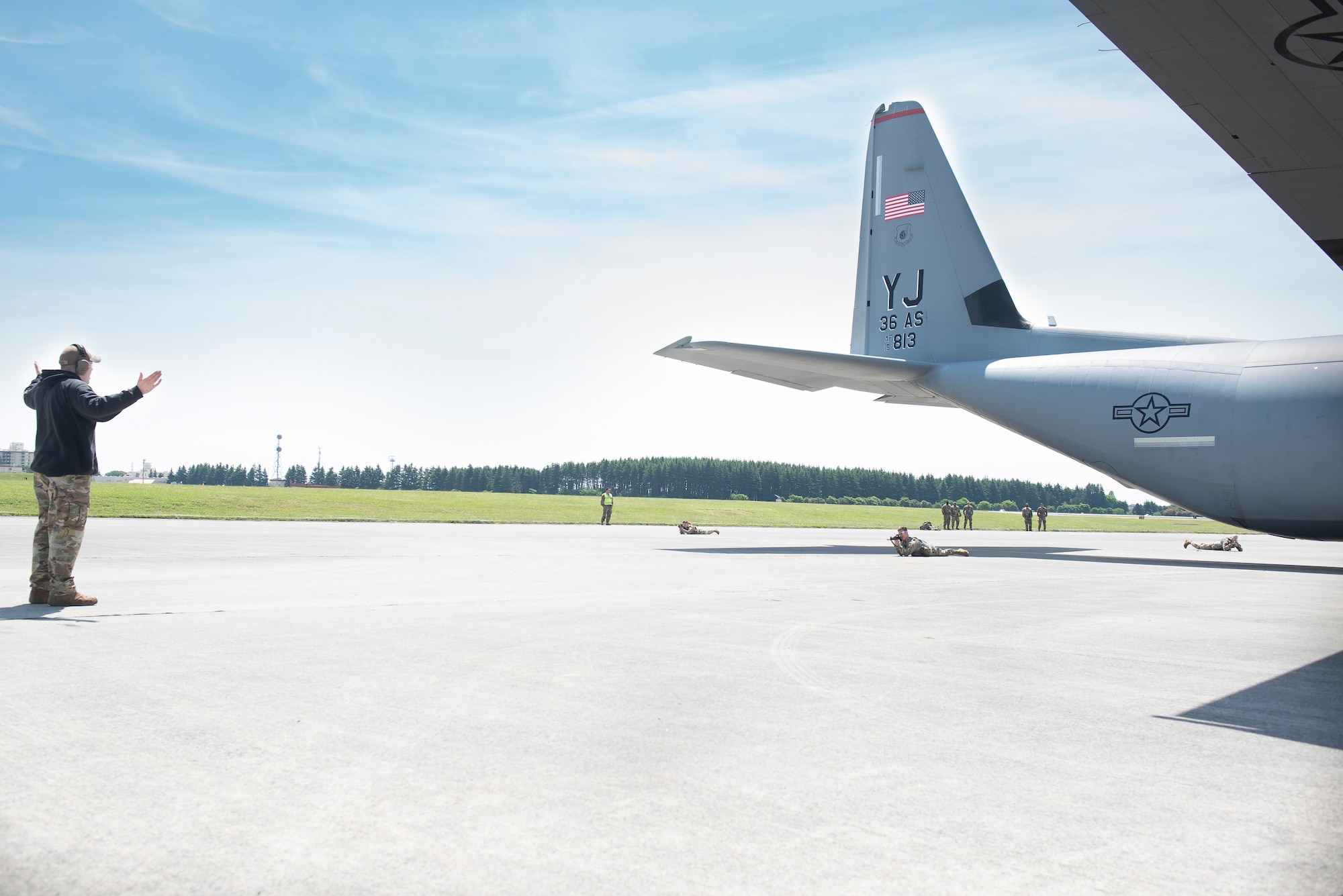 Airmen participating in fly-away security training aim a weapon at a simulated hostile at Yokota Air Base, Japan, May 10, 2022. Members from the 374th Security Forces Squadron familiarized their own Airmen as well as Airmen from other Squadron with how to secure an aircraft in a location that requires an extra measure of security. In case there are not enough Security Forces members on the aircraft, members from other units will assist in protecting the aircraft from potential threats. (U.S. Air Force photo by Machiko Arita)