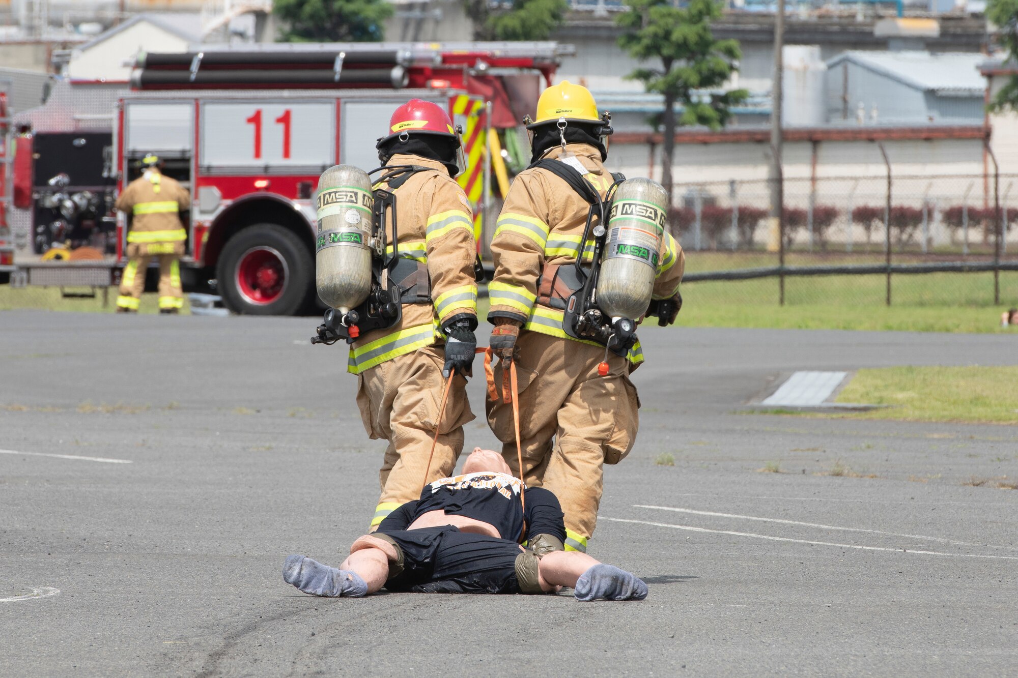 Firefighters with the 374th Civil Engineer Squadron Fire Department pull a simulated injured person to safety during a major accident response exercise at Yokota Air Base, Japan, May 11, 2022. The MARE tested the base’s response to a simulated F-16 Fighting Falcon crash and the ability to collaborate with mission partners. Due to the support of Naval Air Facility Atsugi, Commander Fleet Activities Yokosuka, Misawa Air Base and Tokyo Fire Department, Fussa Fire Station, this was the largest MARE in Yokota history. (U.S. Air Force photo by Machiko Arita)