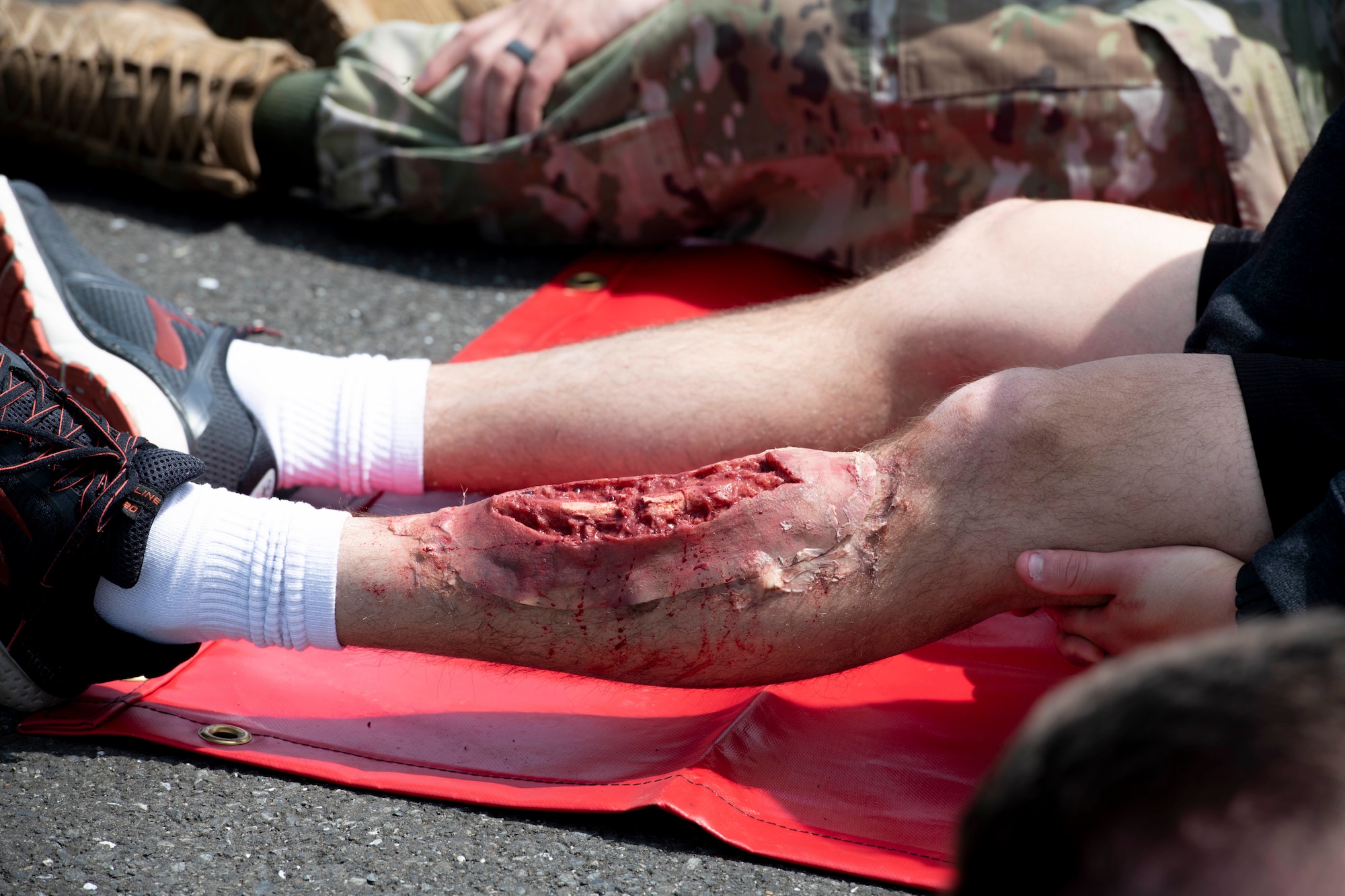 A simulated injured person waits for additional medical care during a major accident response exercise at Yokota Air Base, Japan, May 11, 2022. The MARE tested the base’s response to a simulated F-16 Fighting Falcon crash and the ability to collaborate with mission partners. Due to the support of Naval Air Facility Atsugi, Commander Fleet Activities Yokosuka, Misawa Air Base and Tokyo Fire Department, Fussa Fire Station, this was the largest MARE in Yokota history. (U.S. Air Force photo by Machiko Arita)