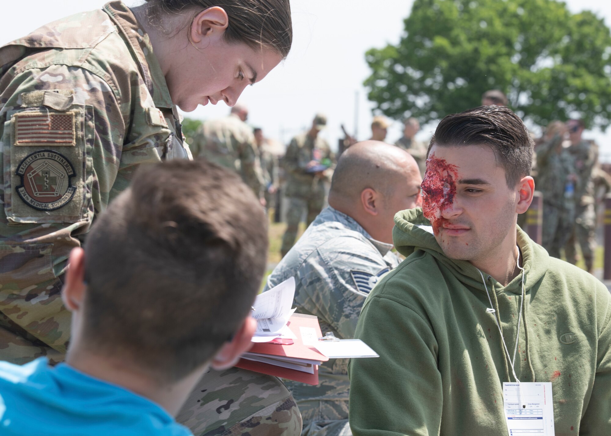 A member of the 374th Medical Group assists an individual with his simulated injuries during a major accident response exercise at Yokota Air Base, Japan, May 11, 2022. The MARE tested the base’s response to a simulated F-16 Fighting Falcon crash and the ability to collaborate with mission partners. Due to the support of Naval Air Facility Atsugi, Commander Fleet Activities Yokosuka, Misawa Air Base and Tokyo Fire Department, Fussa Fire Station, this was the largest MARE in Yokota history. (U.S. Air Force photo by Machiko Arita)