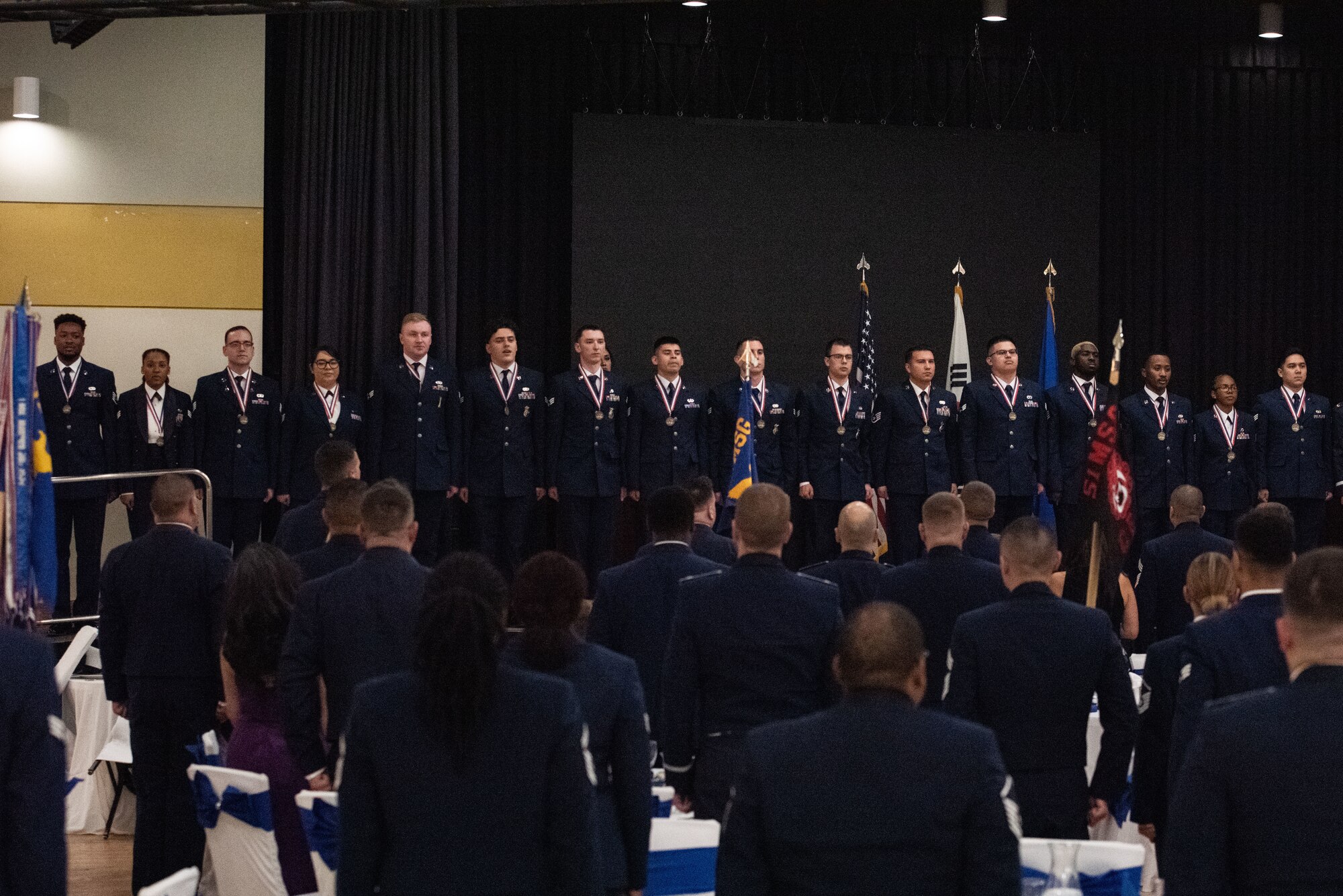 Airman Leadership graduates sing the Air Force song with the audience