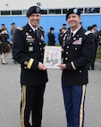 Lt. Col. David Gladish presents Maj. Gen. Jeff Broadwater with a gift of appreciation following the commencement ceremony for Intermediate Level Education – Common Core class of 2022 at the 7th Intermediate Level Education Detachment, 7th Mission Support Command, Grafenwoehr, Germany, May 6, 2022. 

The 7th ILE Detachment is the only Command and General Staff College in the European theater and provides education for EUCOM, AFRICOM, and CENTCOM and is one of two training facilities to host international students.