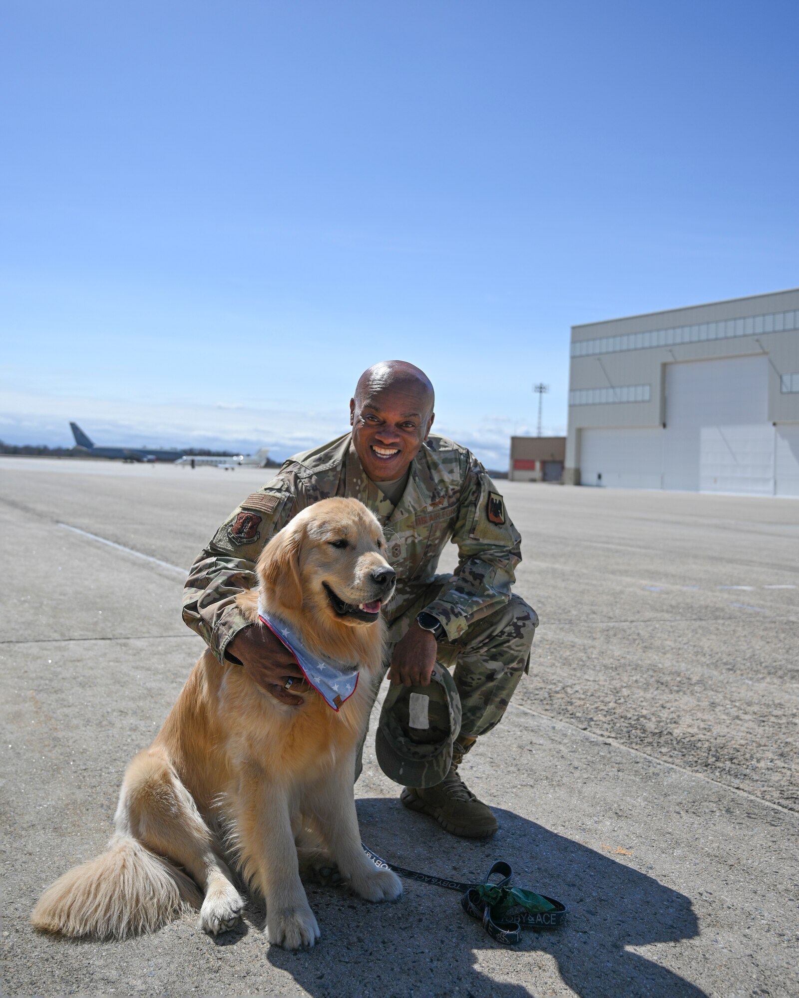 U.S. Air Force Chief Master Sgt. Tony Whitehead pets golden retriever dog