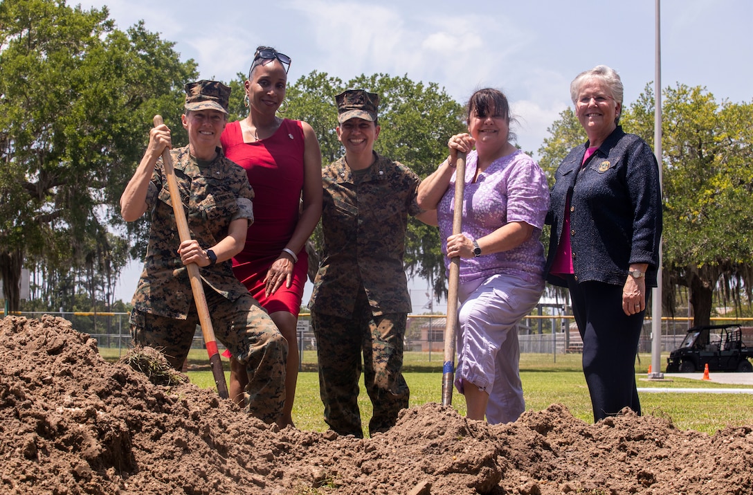 Brig. Gen. Julie L. Nethercot, Marine Corps Recruit Depot Parris Island and Eastern Recruiting Region Commanding General (left), Sgt. Maj. Robin C. Fortner (Ret.) (left center), Lt. Col. Axia R. Dones, 4th Recruit Training Battalion Commanding Officer (center), Col. Maria Marte (Ret.) (center right), and Rhonda Amtower, National President of the Women Marines Association, pose for a photo in front of the exposed time capsule on Marine Corps Recruit Depot Parris Island S.C., May 5, 2022. The time capsule was buried on February 13, 2012 as a part of the celebration of 69 years of continued service by women in the Marine Corps.