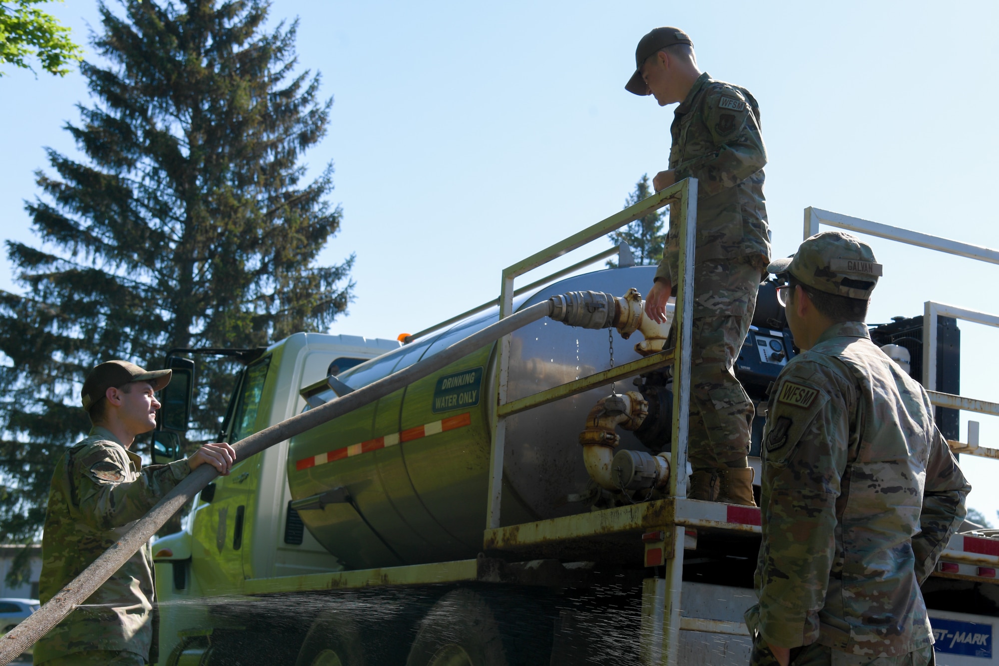 men fill water truck