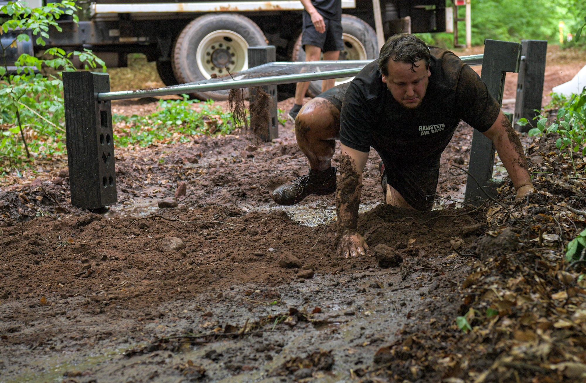 man crawls through mud