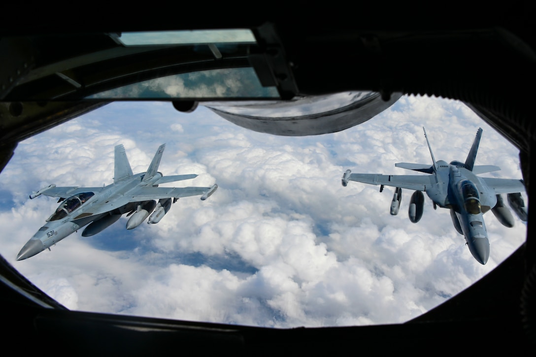 Two aircraft fly above the clouds.