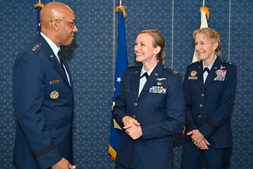 Three airmen stand together.