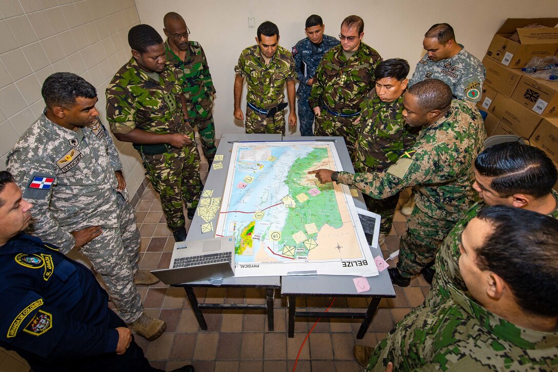 Captain Nickalious Beaumont (Jamaica Defence Force, pointing at map) and members of the Caribbean Task Force simulate the employment of military resources for military operations during Exercise TRADEWINDS 2022 in Belize City, Belize, on May 12, 2022.