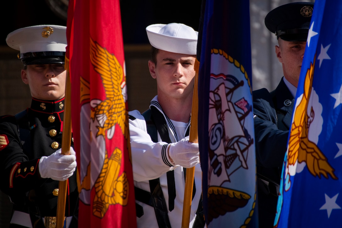 Members of a color guard hold flags.