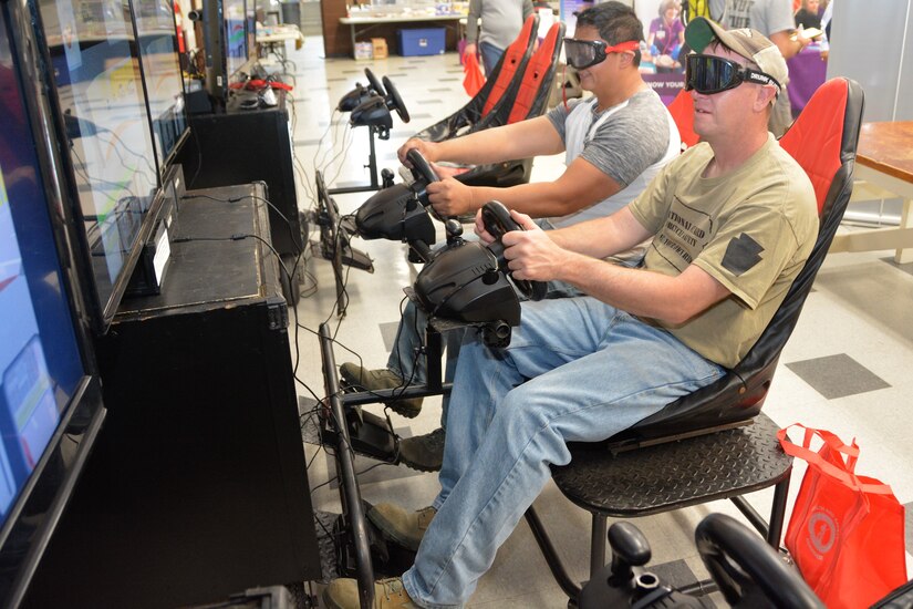 Attendees at Health and Safety Awareness Day use a distracted driving simulator wearing goggles to simulate the effects of alcohol on May 12, 2022, at Fort Indiantown Gap, Pa.