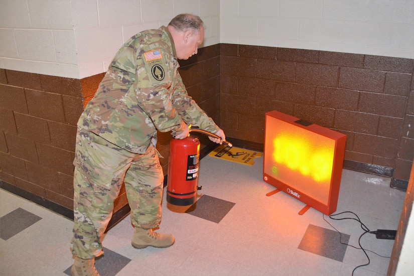 Master Sgt. Michael Coleman of the Pennsylvania Army National Guard State Safety Office demonstrates how to use a fire extinguisher simulator at Health and Safety Awareness Day on May 12, 2022, at Fort Indiantown Gap, Pa.