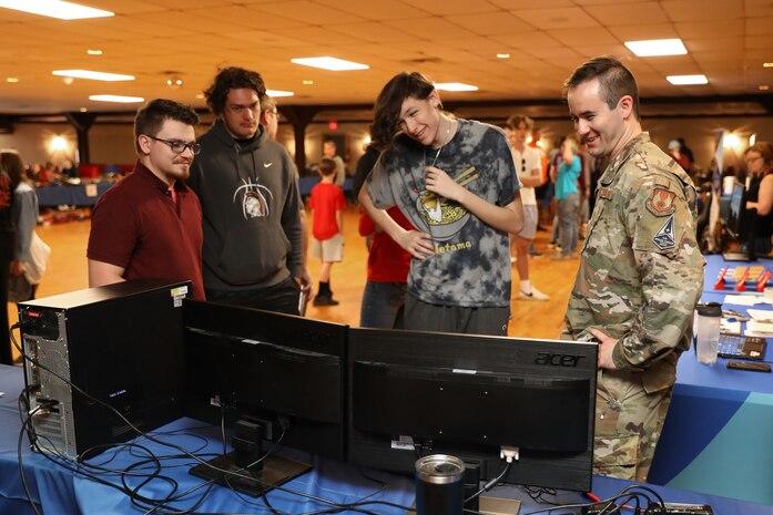 WRIGHT-PATTERSON AIR FORCE BASE (AFRL), Ohio – First Lt. Kyle Bucklew, right, warfighter training program manager, 711th Human Performance Wing, part of Air Force Research Laboratory, interacts with students during the Full Throttle STEM event May 10, 2022, at Eldora Speedway in Rossburg, Ohio. The Air Force Research Laboratory’s Gaming Research Integration for Learning Lab, or GRILL, hosted the science, technology, engineering and math events with 12 schools in attendance between both locations. (U.S. Air Force photo / Will Graver)