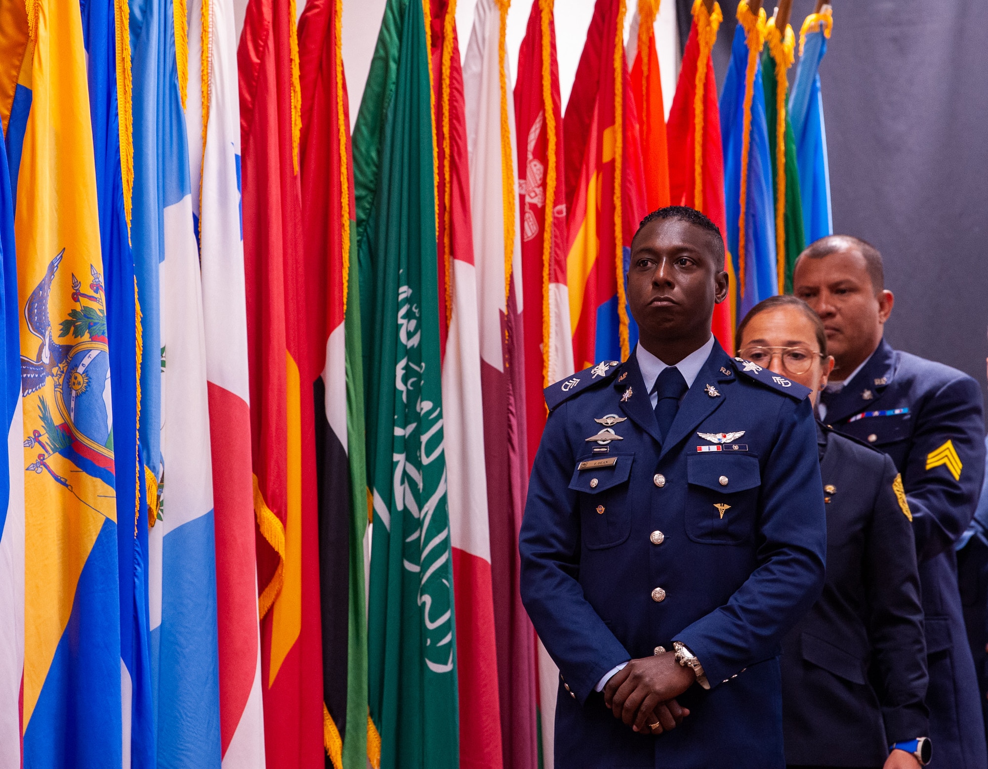 International students stand next to flags