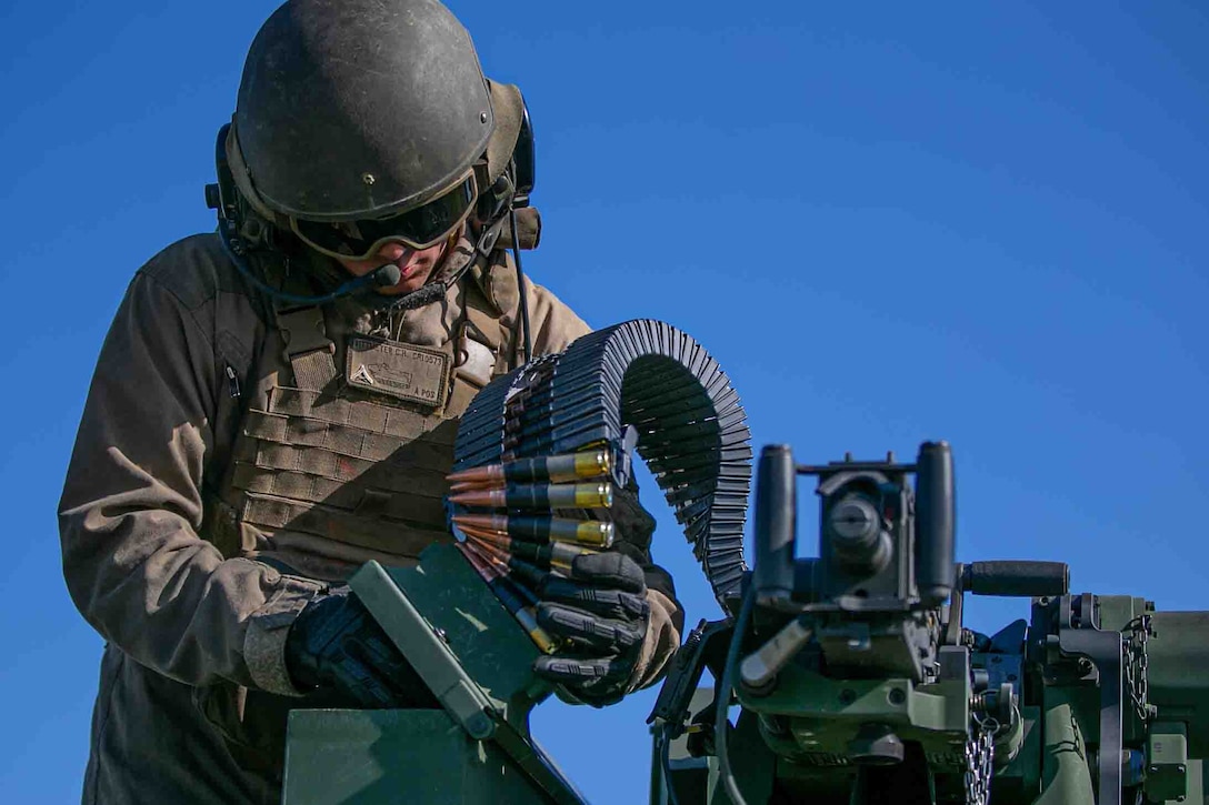 A Marine reloads a machine gun.