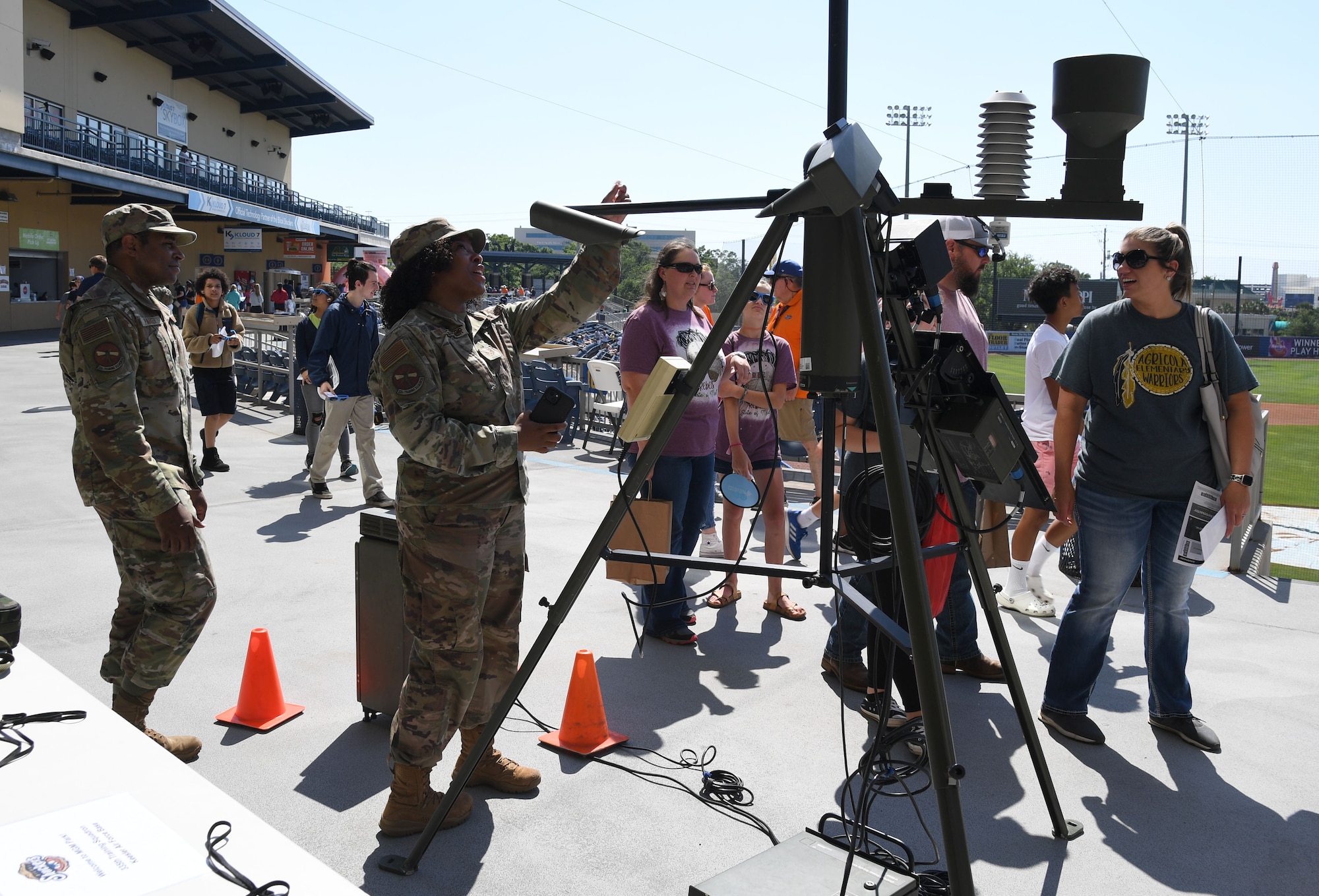 U.S. Air Force Tech. Sgt. Jarrett Parker and Staff Sgt. Greggria Sylvester, 335th Training Squadron instructors, provide a briefing on a tactical meteorological observational system to parents, students and teachers from Agricola Elementary School during the Biloxi Shuckers Education Day event in Biloxi, Mississippi, May 11, 2022. The event allowed Airmen from the 81st Training Group to set up training equipment displays for local school-aged children to view during the Biloxi Shuckers' game. (U.S. Air Force photo by Kemberly Groue)