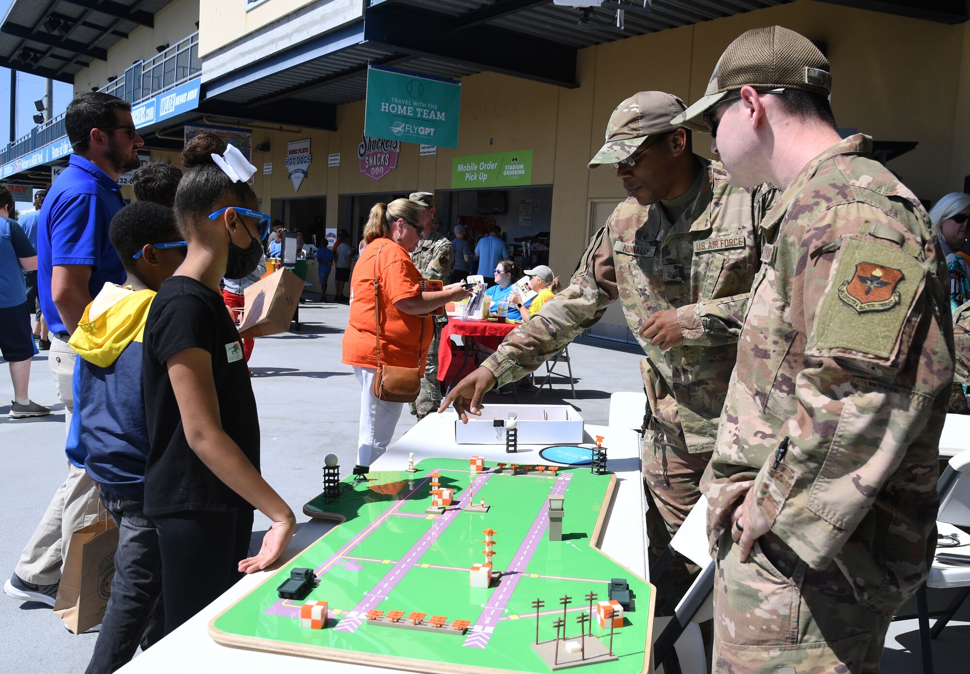 U.S. Air Force Tech. Sgt. Shawn Nunnally, 334th Training Squadron instructor, and Staff Sgt. Zachary Jansen, 334th Training Squadron curriculum developer, provide a briefing on radar airfield and weather systems equipment to students from Gulfport's Central Elementary School during the Biloxi Shuckers Education Day event in Biloxi, Mississippi, May 11, 2022. The event allowed Airmen from the 81st Training Group to set up training equipment displays for local school-aged children to view during the Biloxi Shuckers' game. (U.S. Air Force photo by Kemberly Groue)