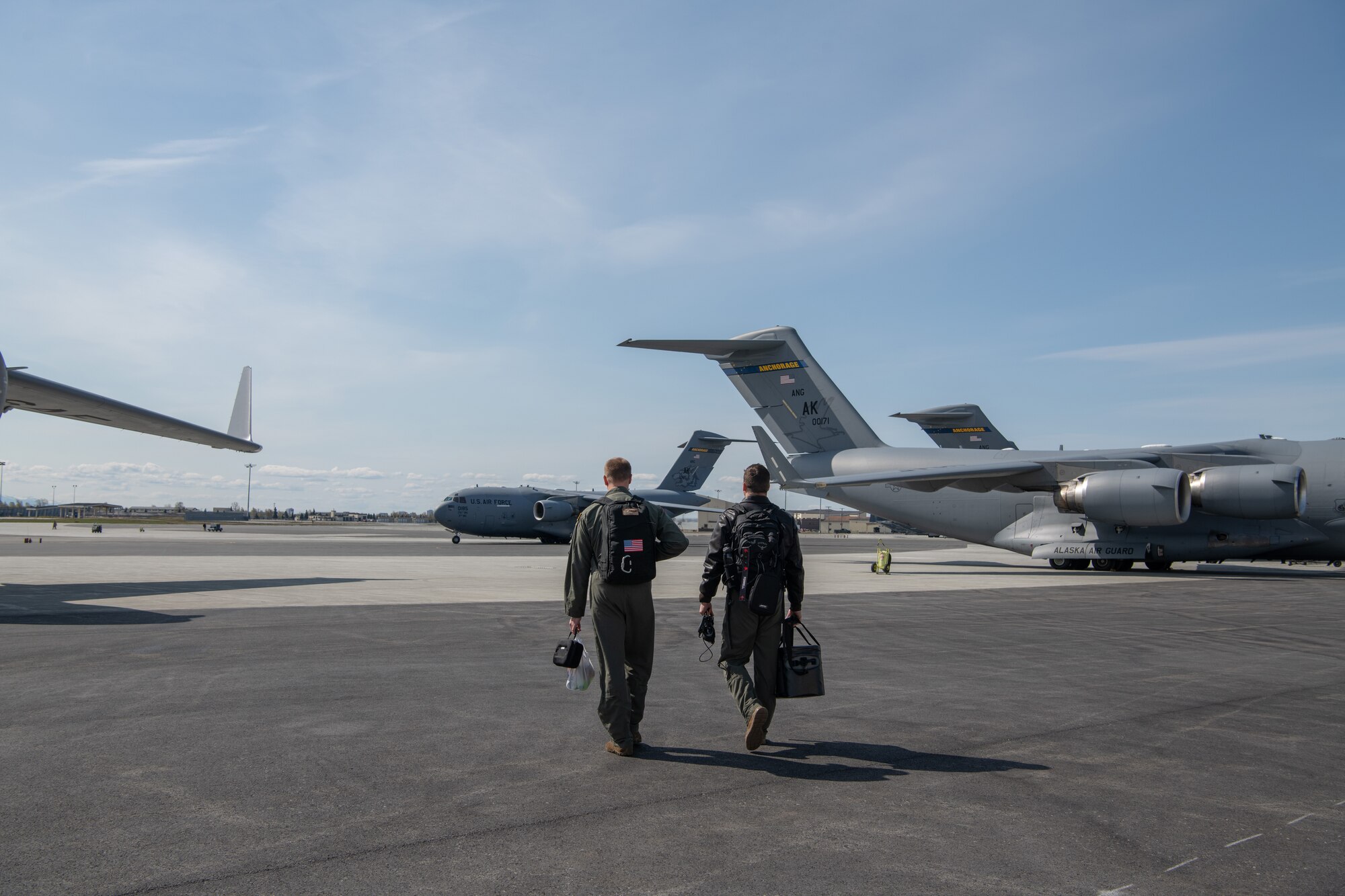 A photo of men walking toward a jet