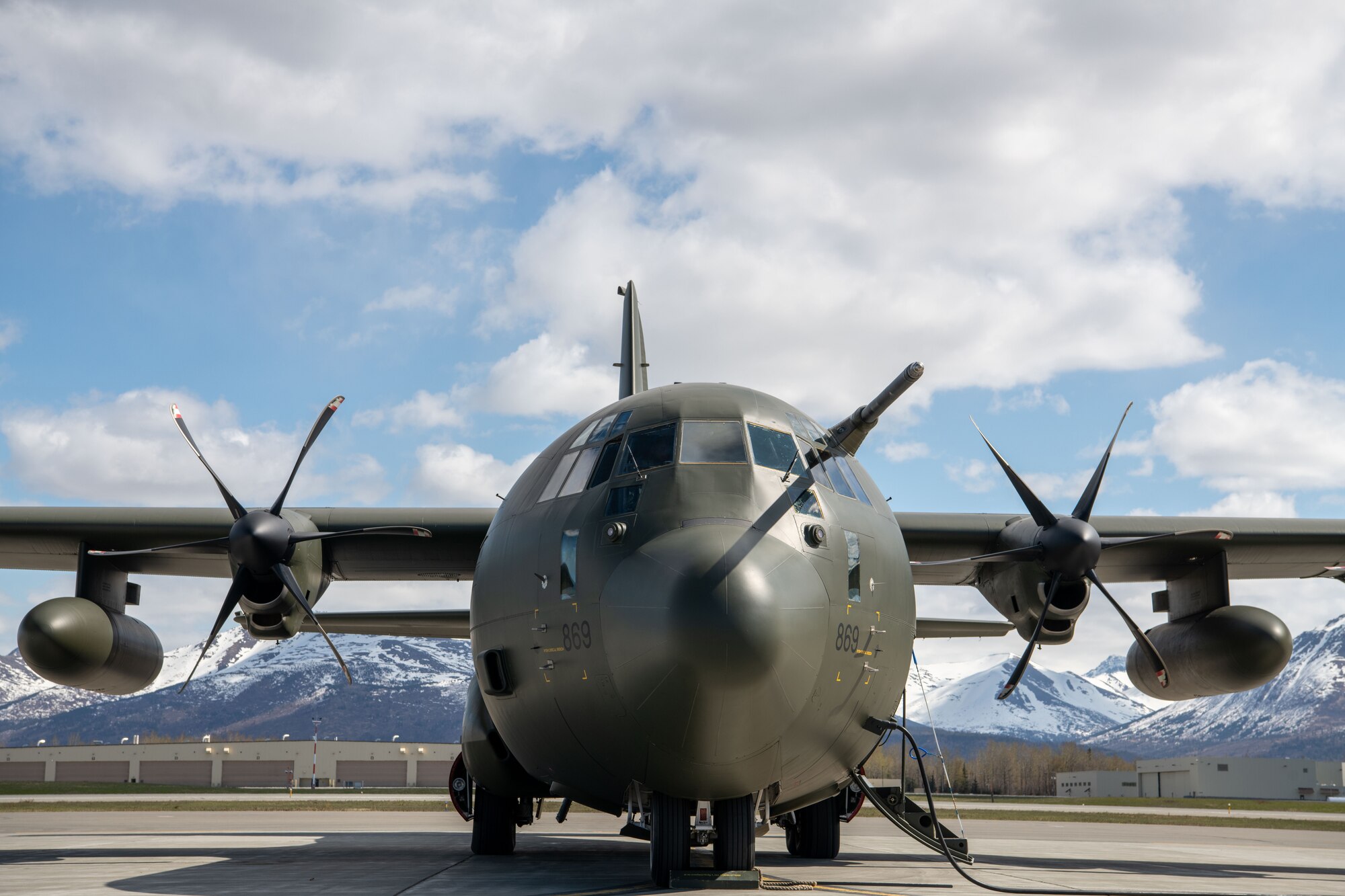 A photo of a green plane sitting on a flightline