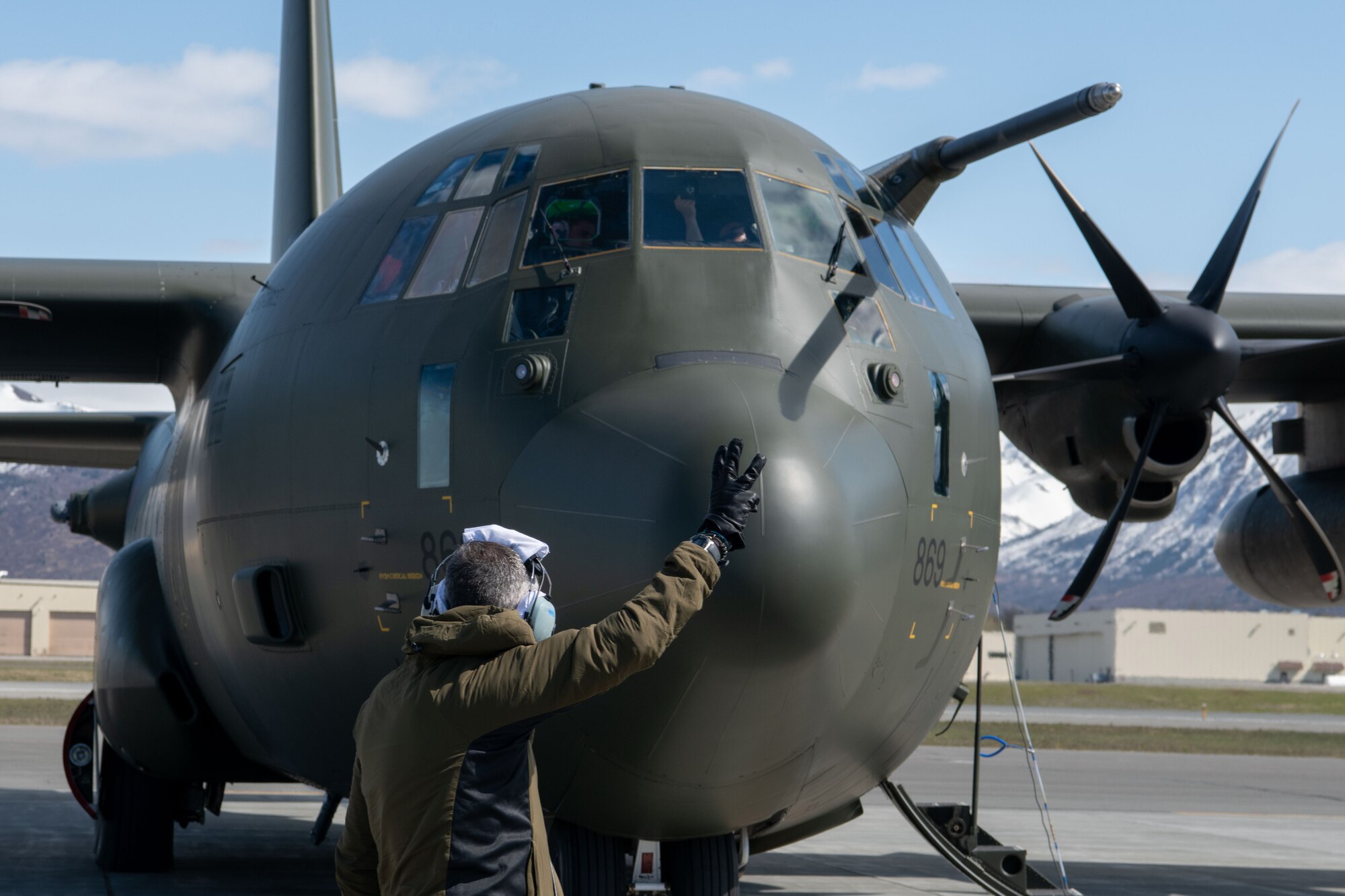 A photo of a man doing hand signals to pilots