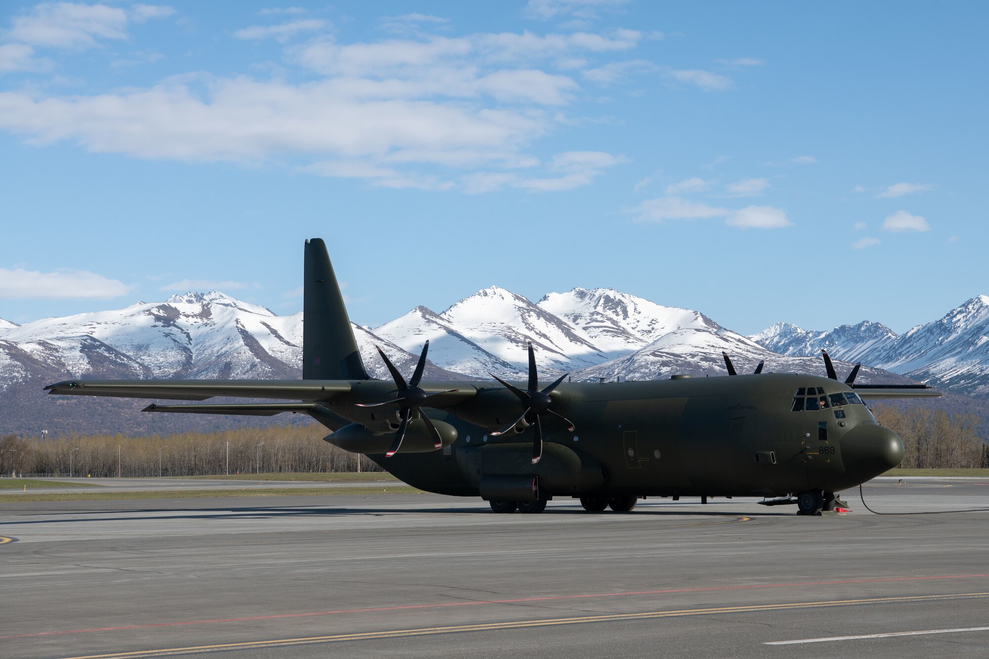 A green plane sits on the flightline