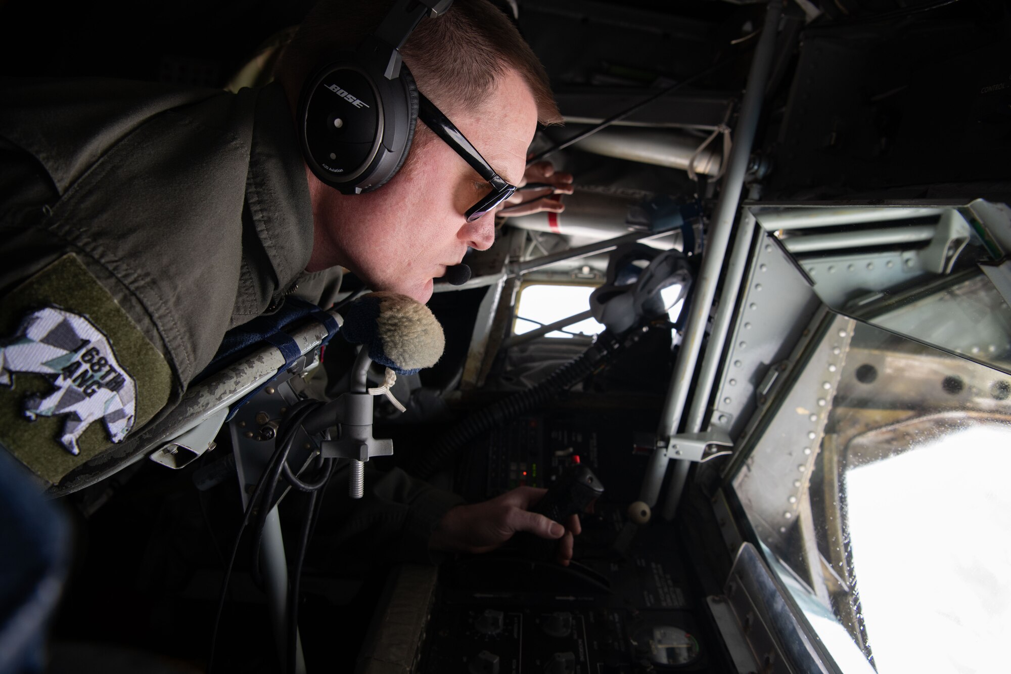 A boom operator refuels planes while flying