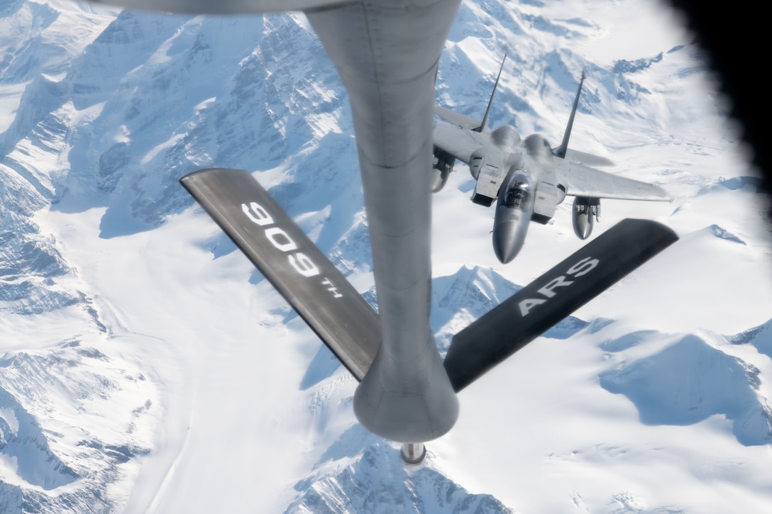 A photo of a plane refueling while flying