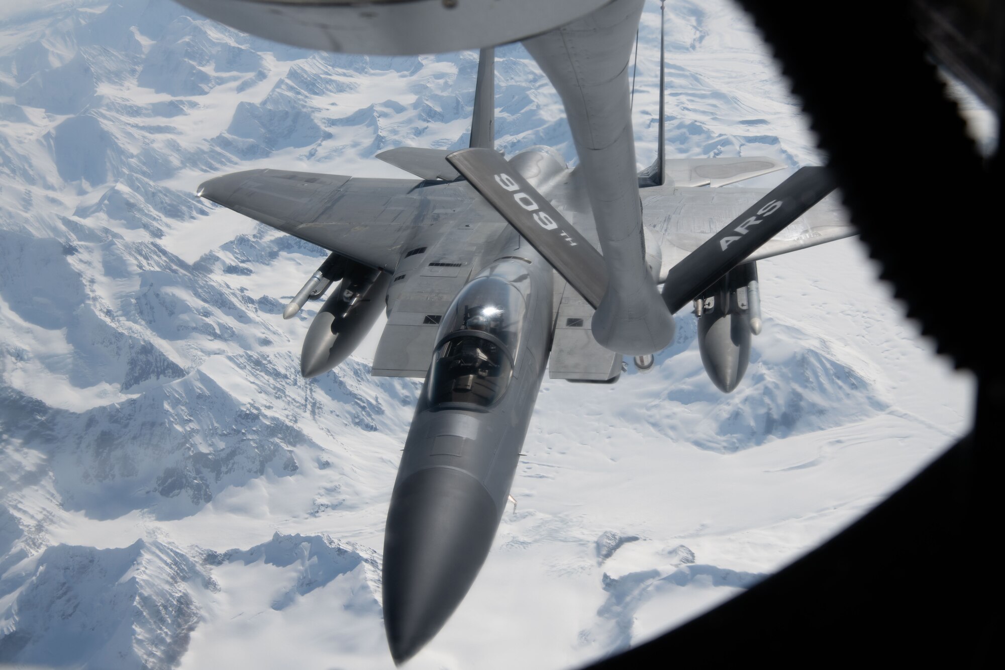 A photo of a plane refueling while flying