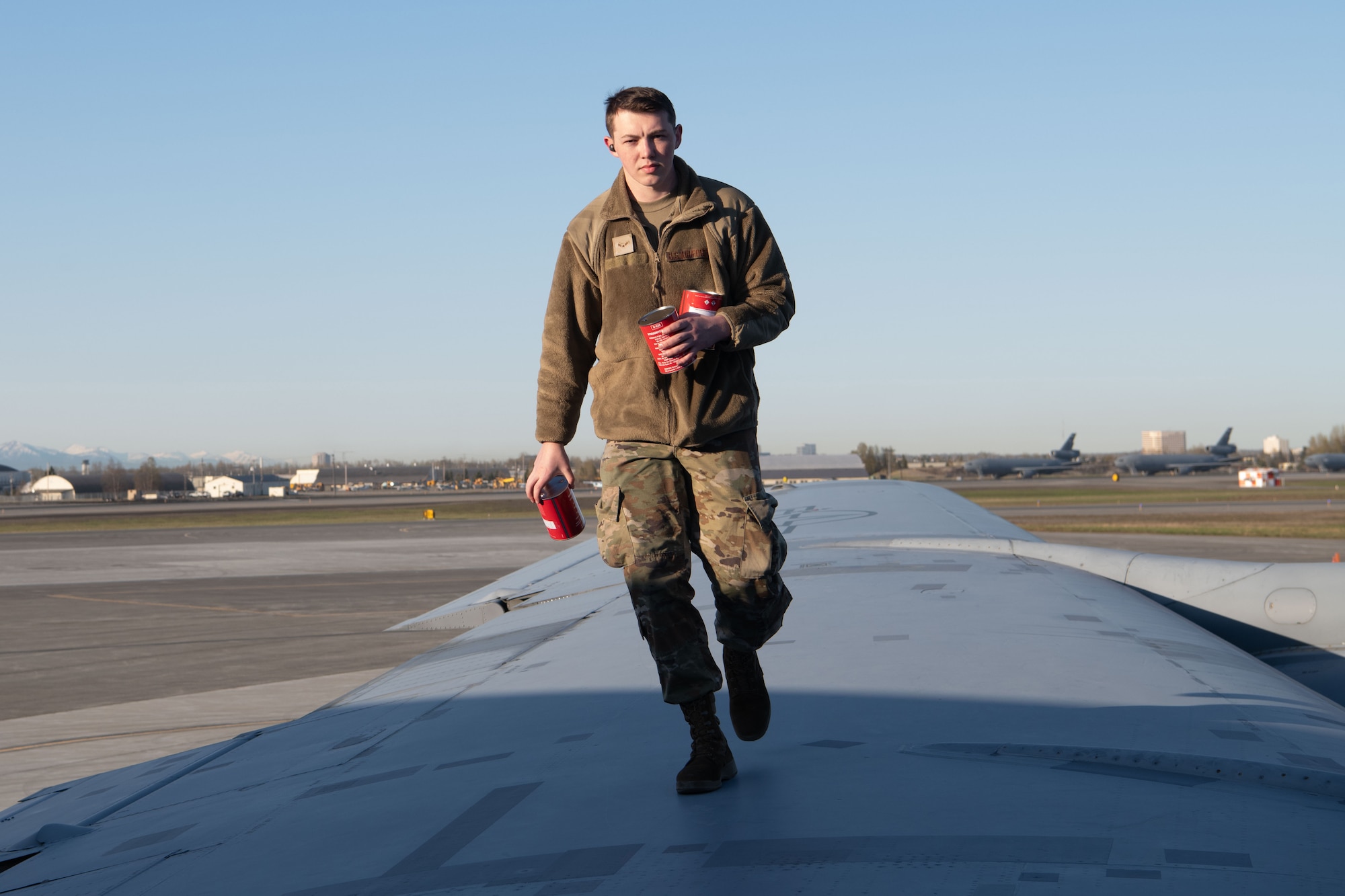 A photo of a man walking on an aircraft wing